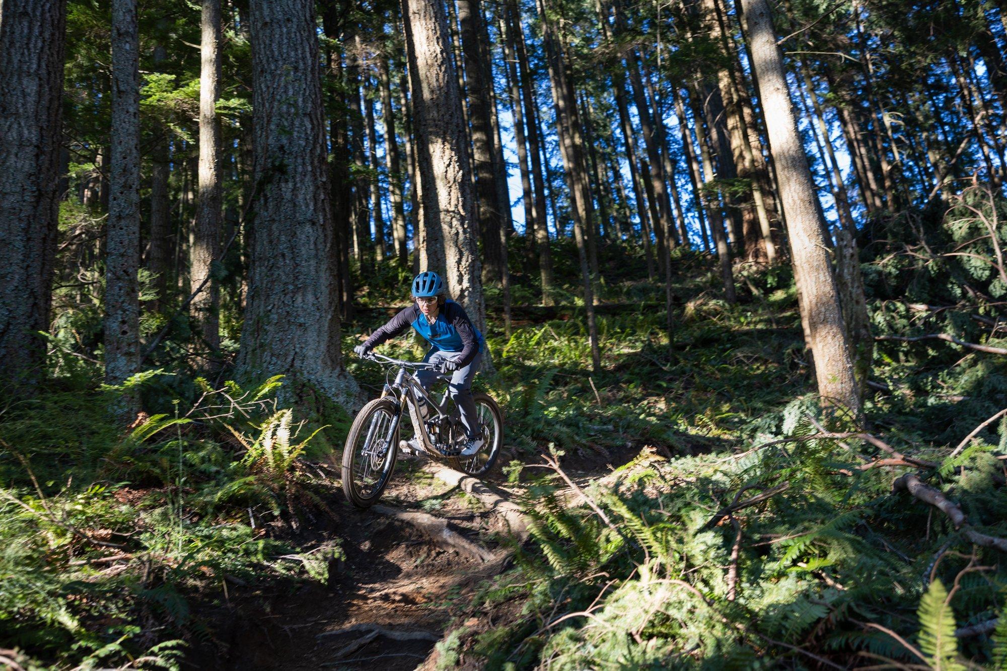 a person riding a mountain bike on a trail in the woods