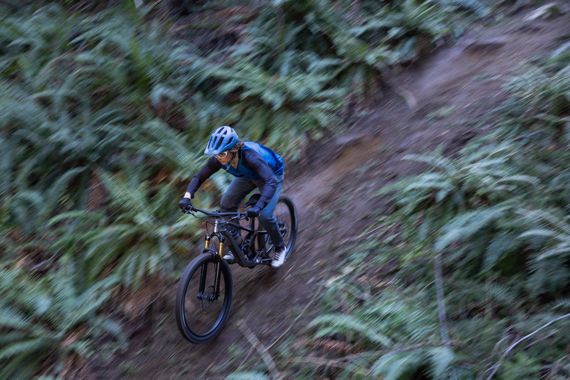 a person riding a mountain bike on a trail in the woods