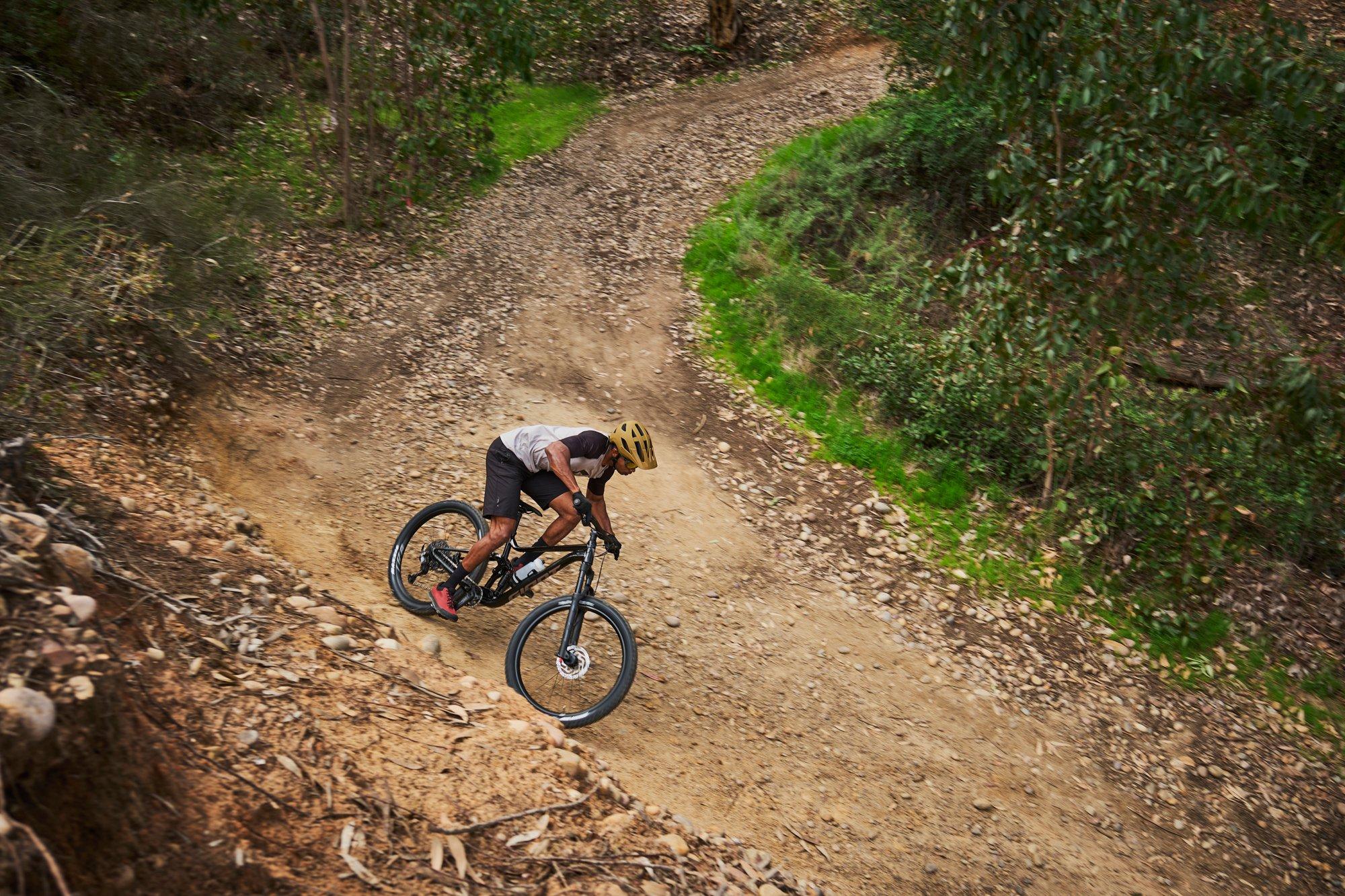 a man riding a mountain bike down a dirt trail