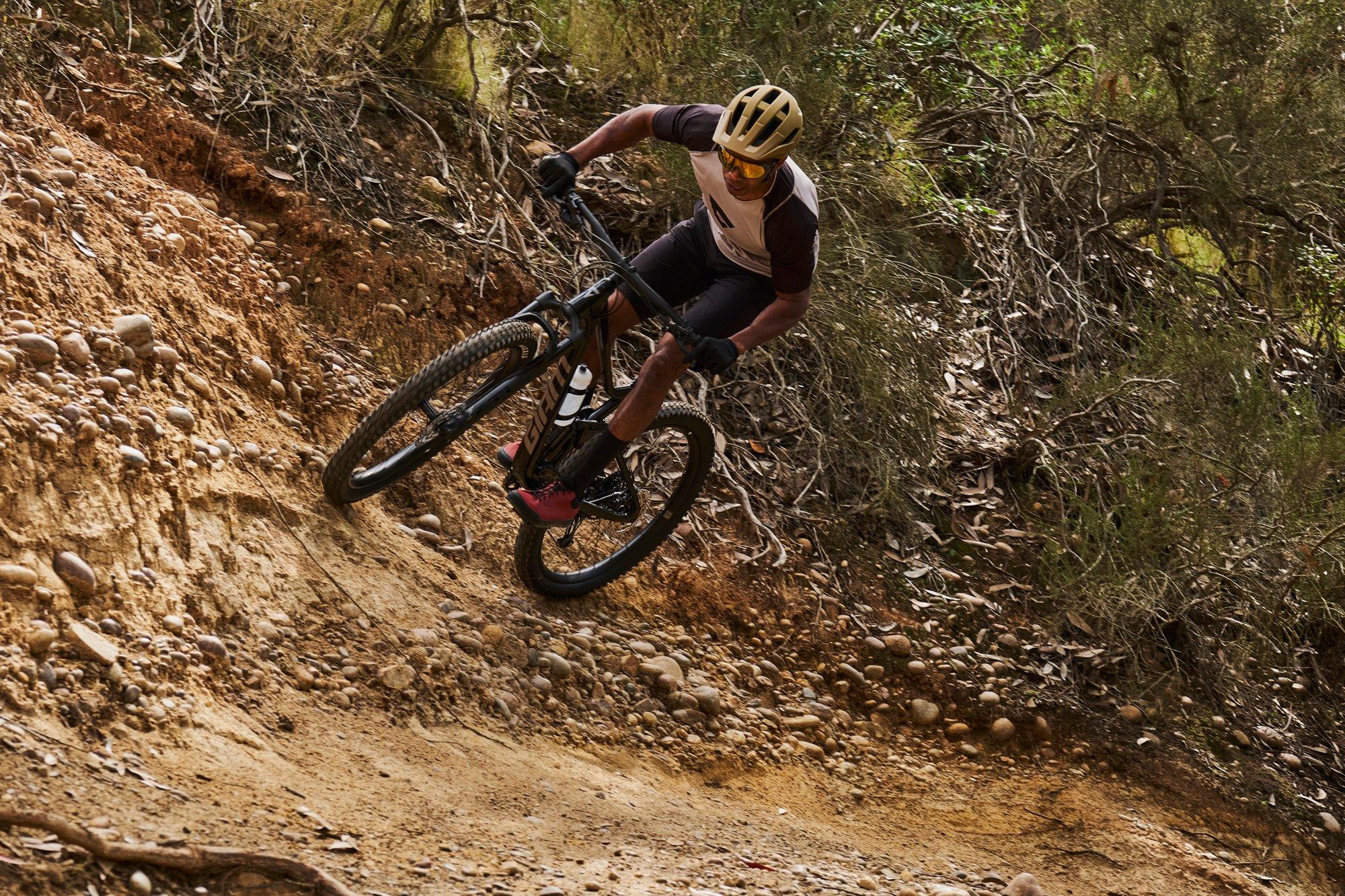 a man riding a mountain bike down a dirt trail