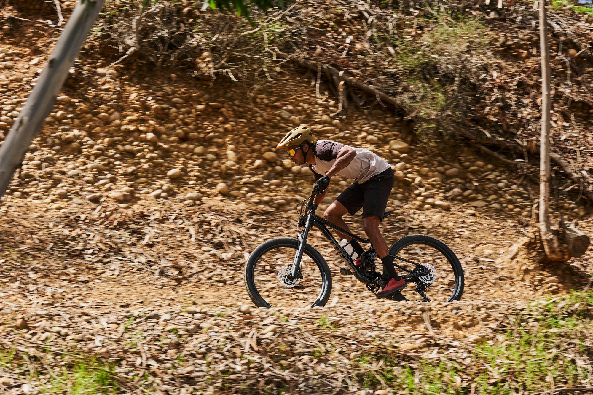 a man riding a mountain bike down a dirt hill