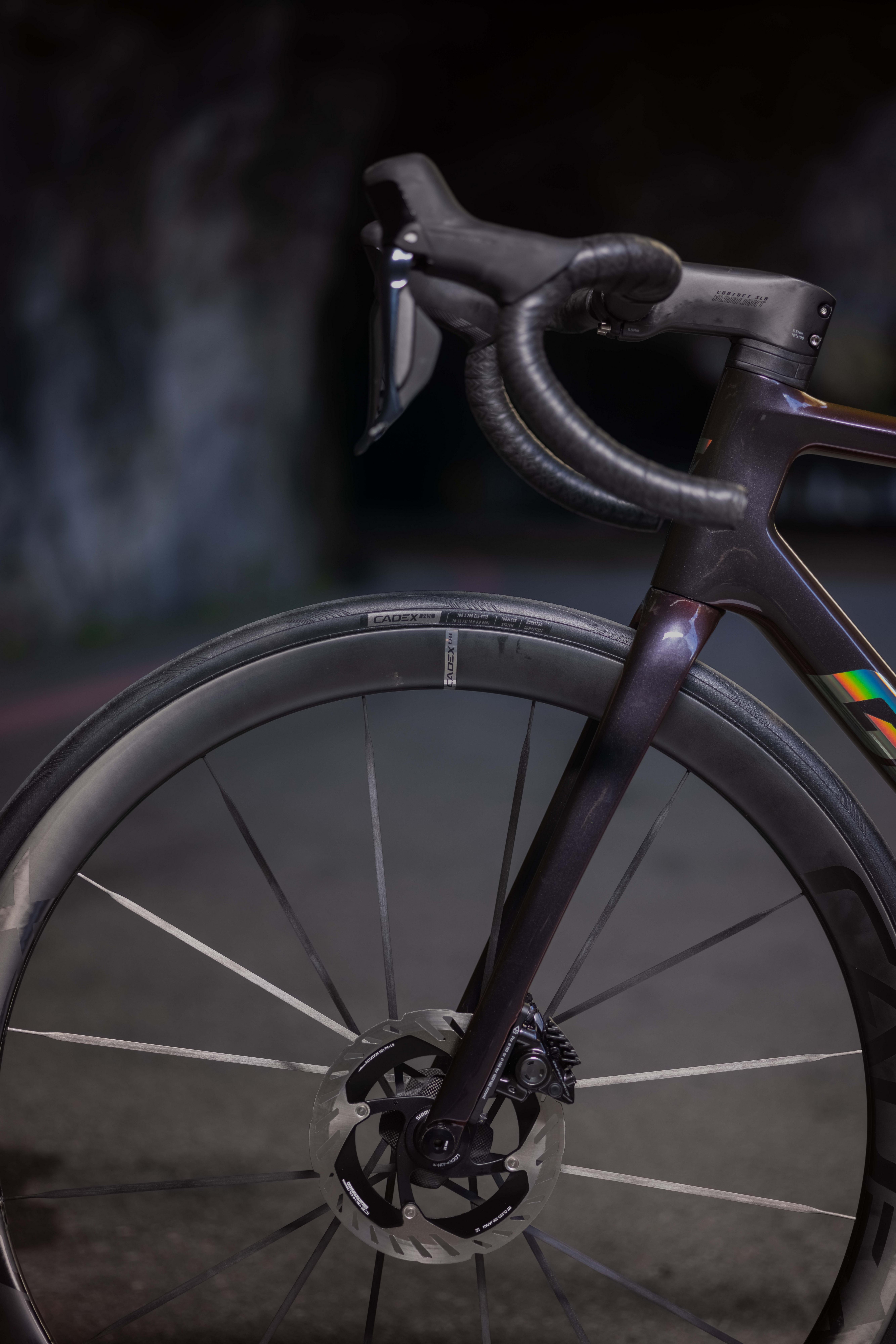 a close up of a bicycle with a colorful stripe on the handlebars