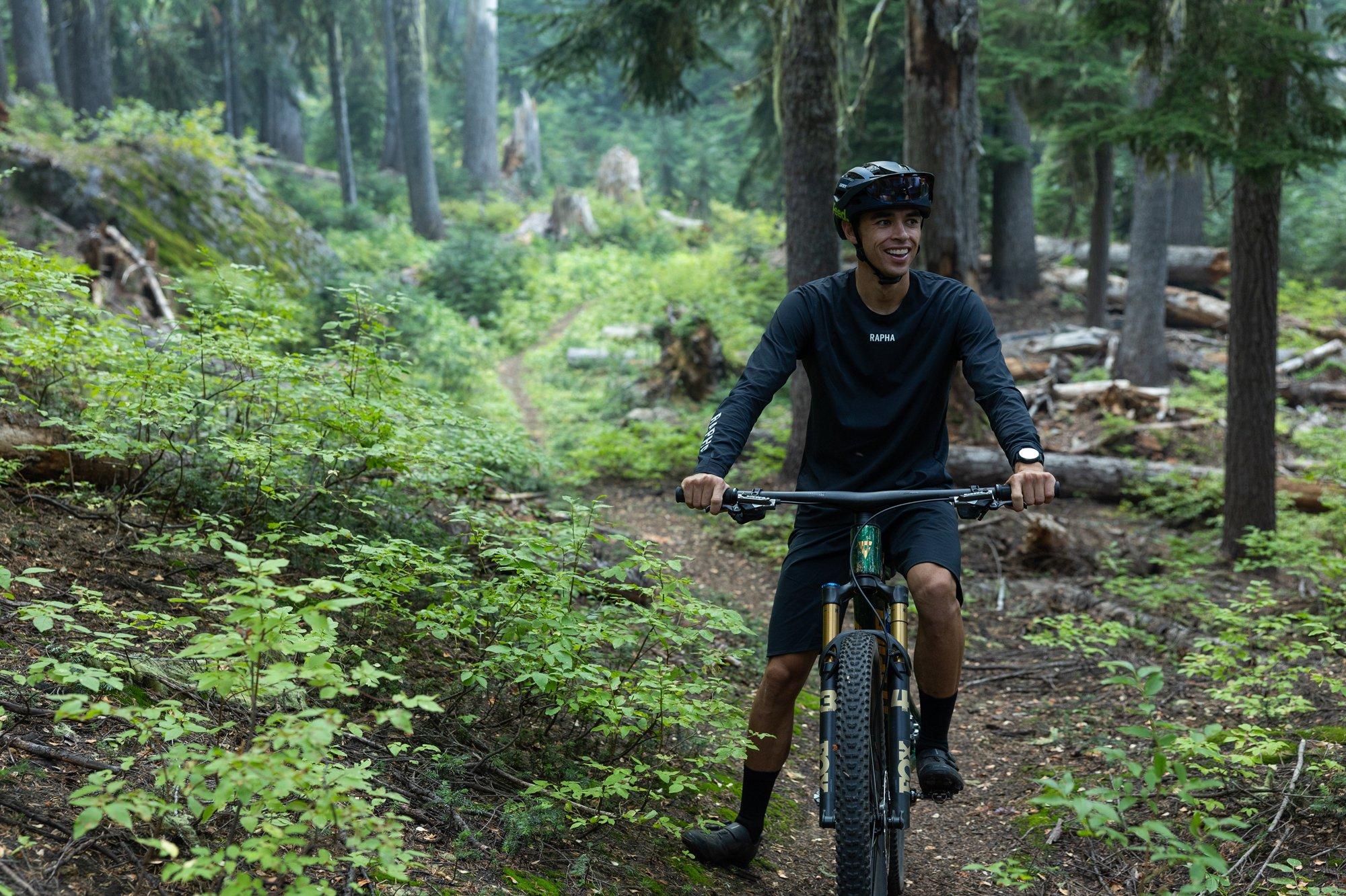 a man riding a mountain bike on a trail in the woods
