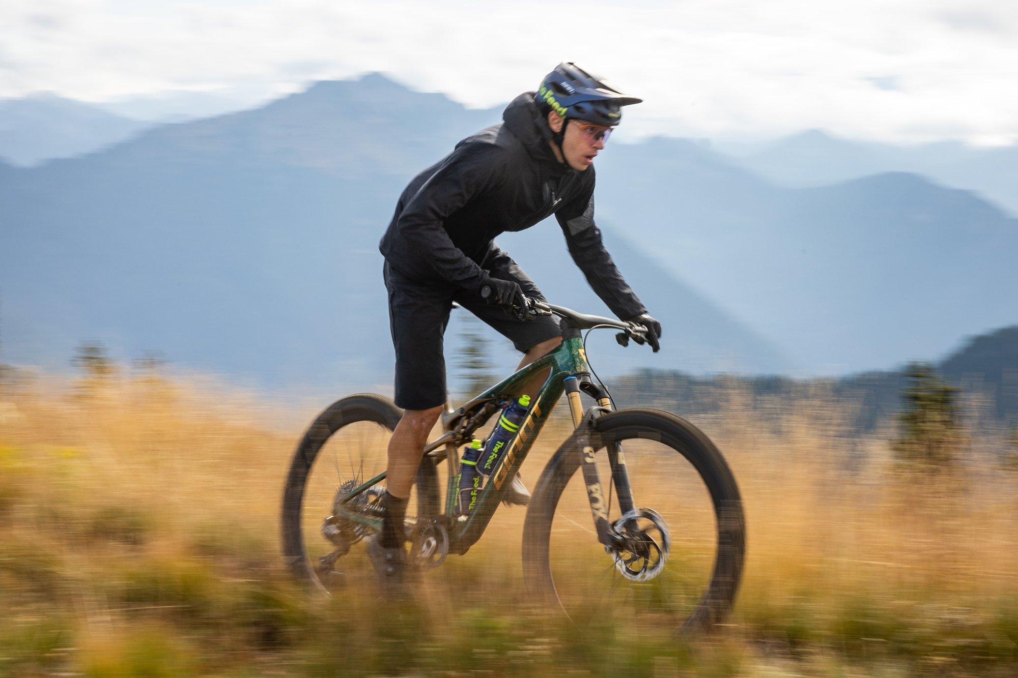 a man riding a mountain bike on a trail in the mountains
