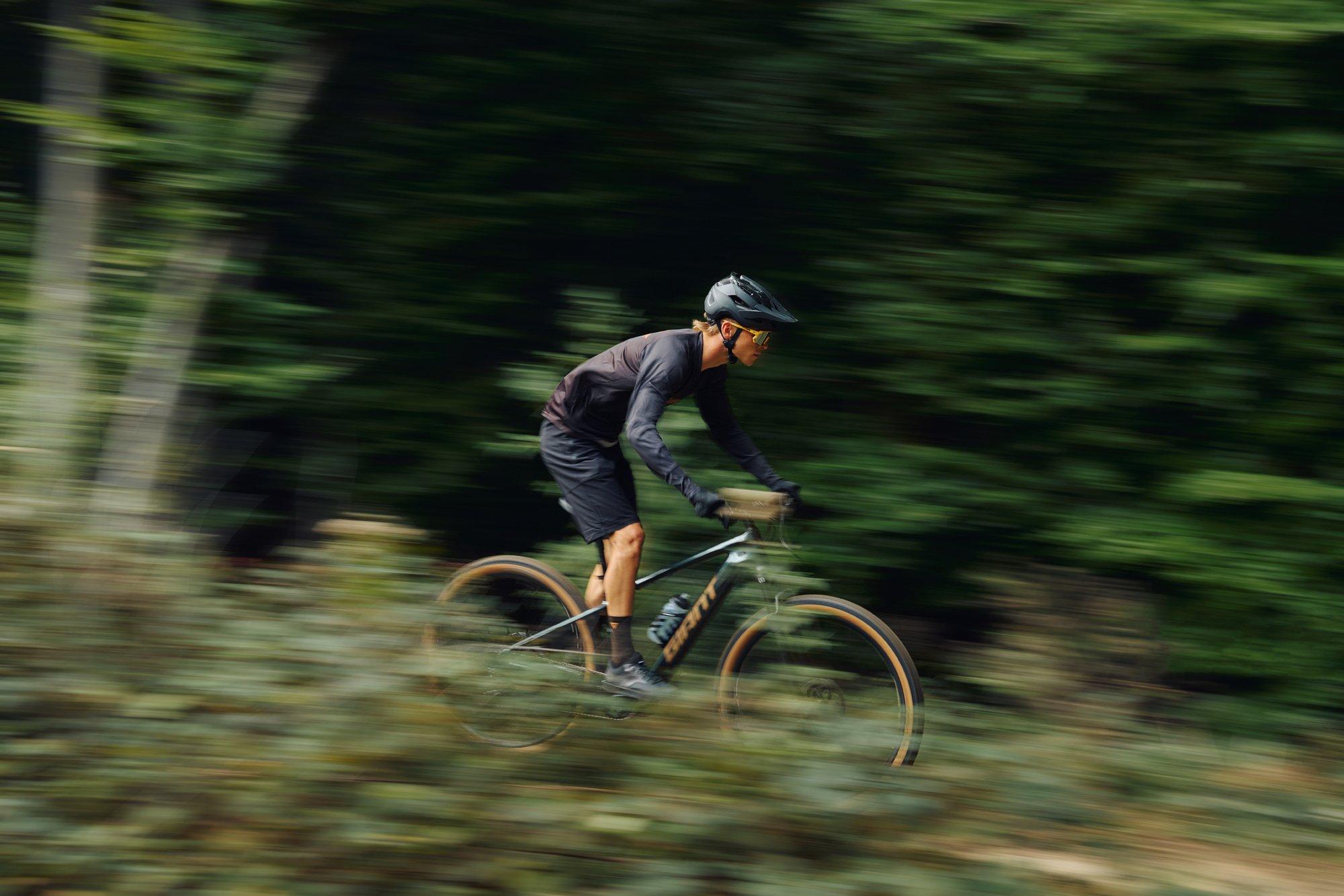 mountain biker riding down trail on electric hardtail