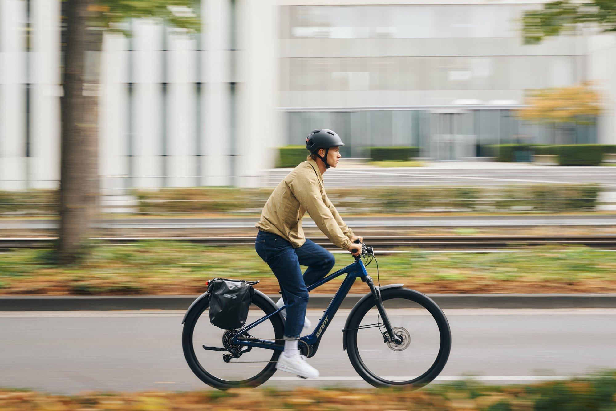 a man riding a bike down a street with a helmet on