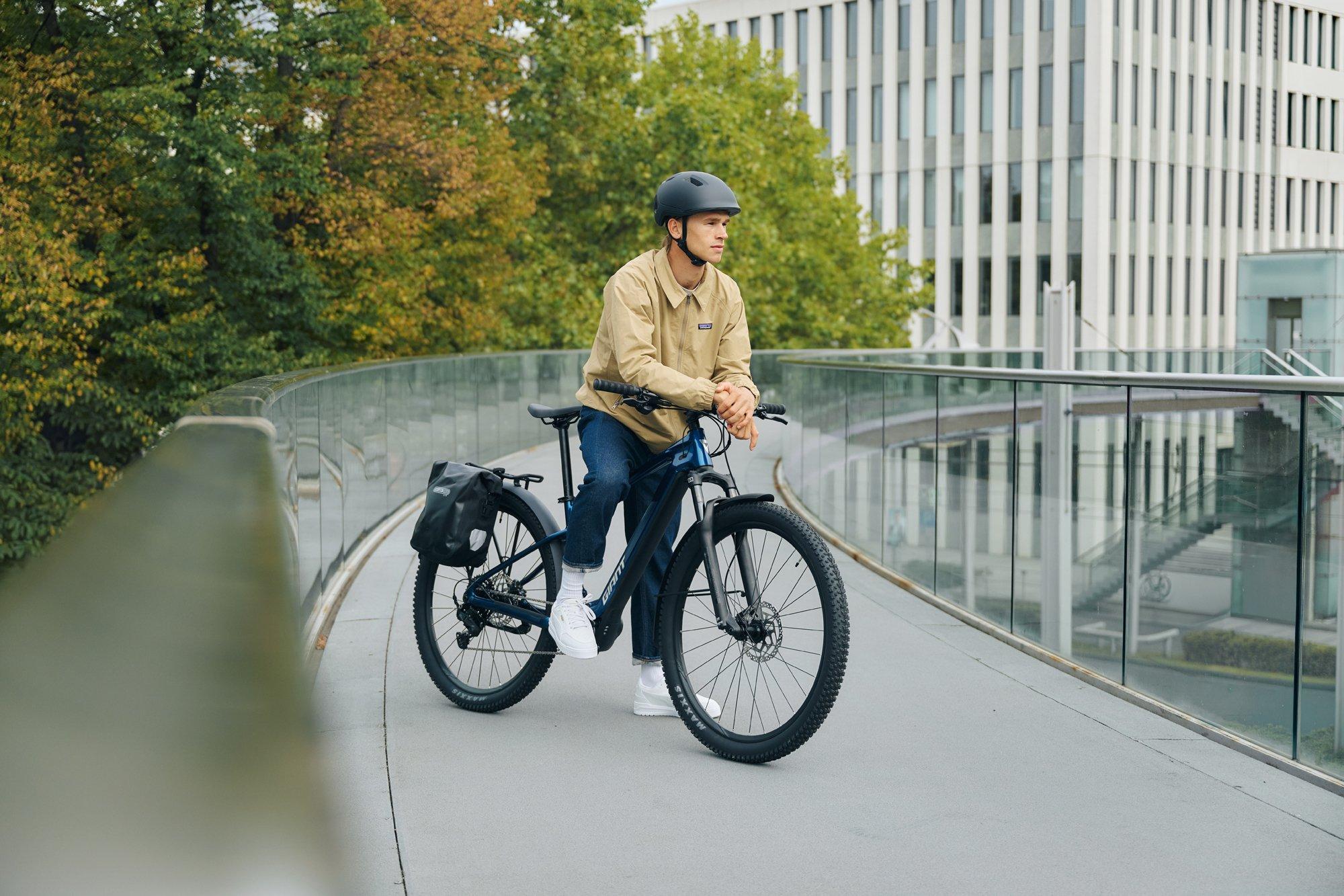 a man riding a bike on a bridge next to a building