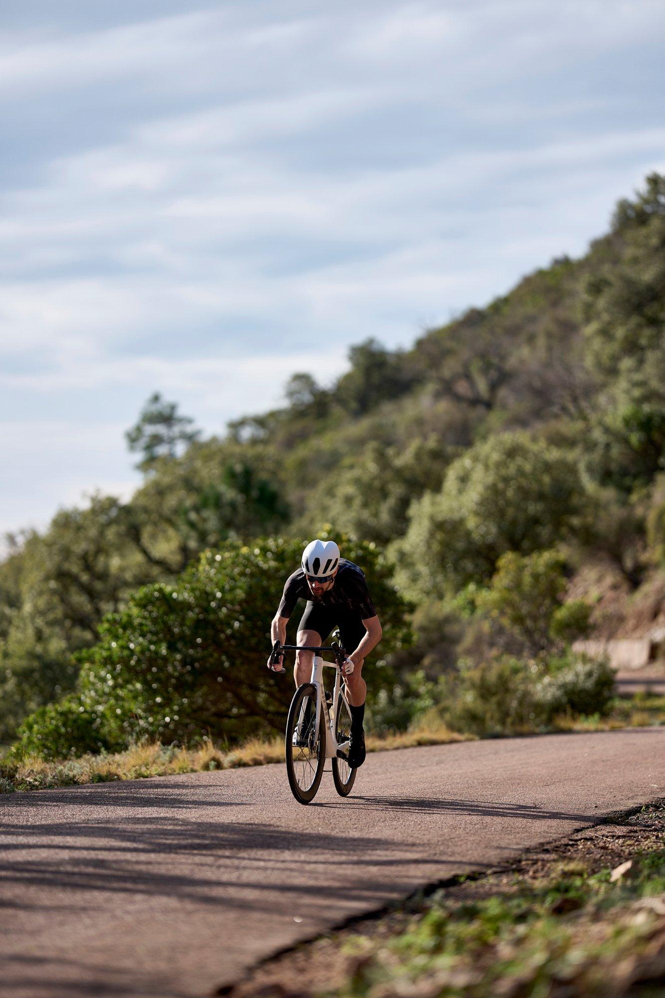 a man riding a bike down a road in the country