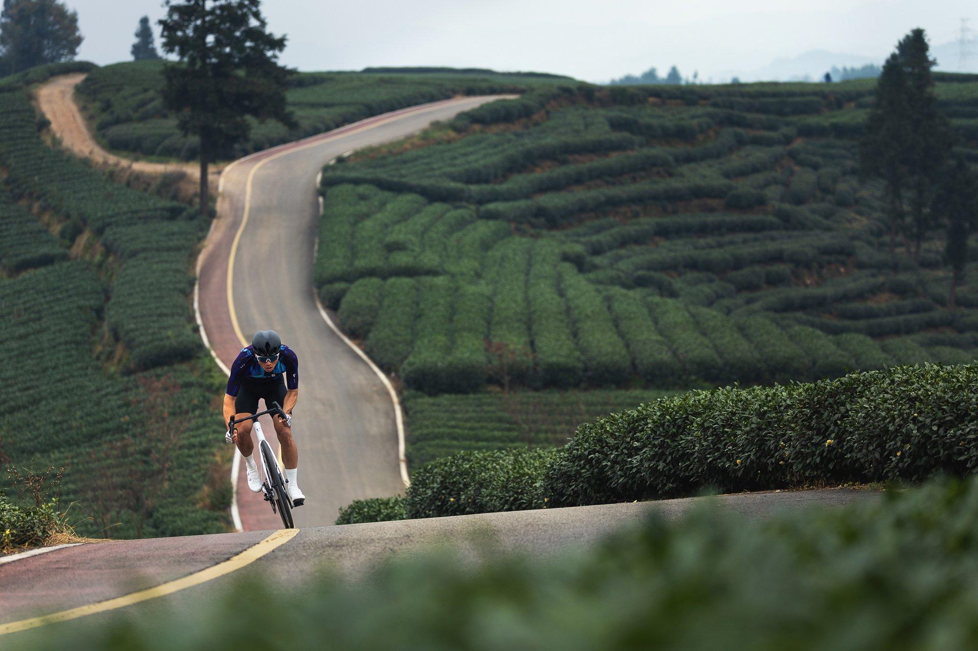 a person riding a bike down a winding road in the countryside