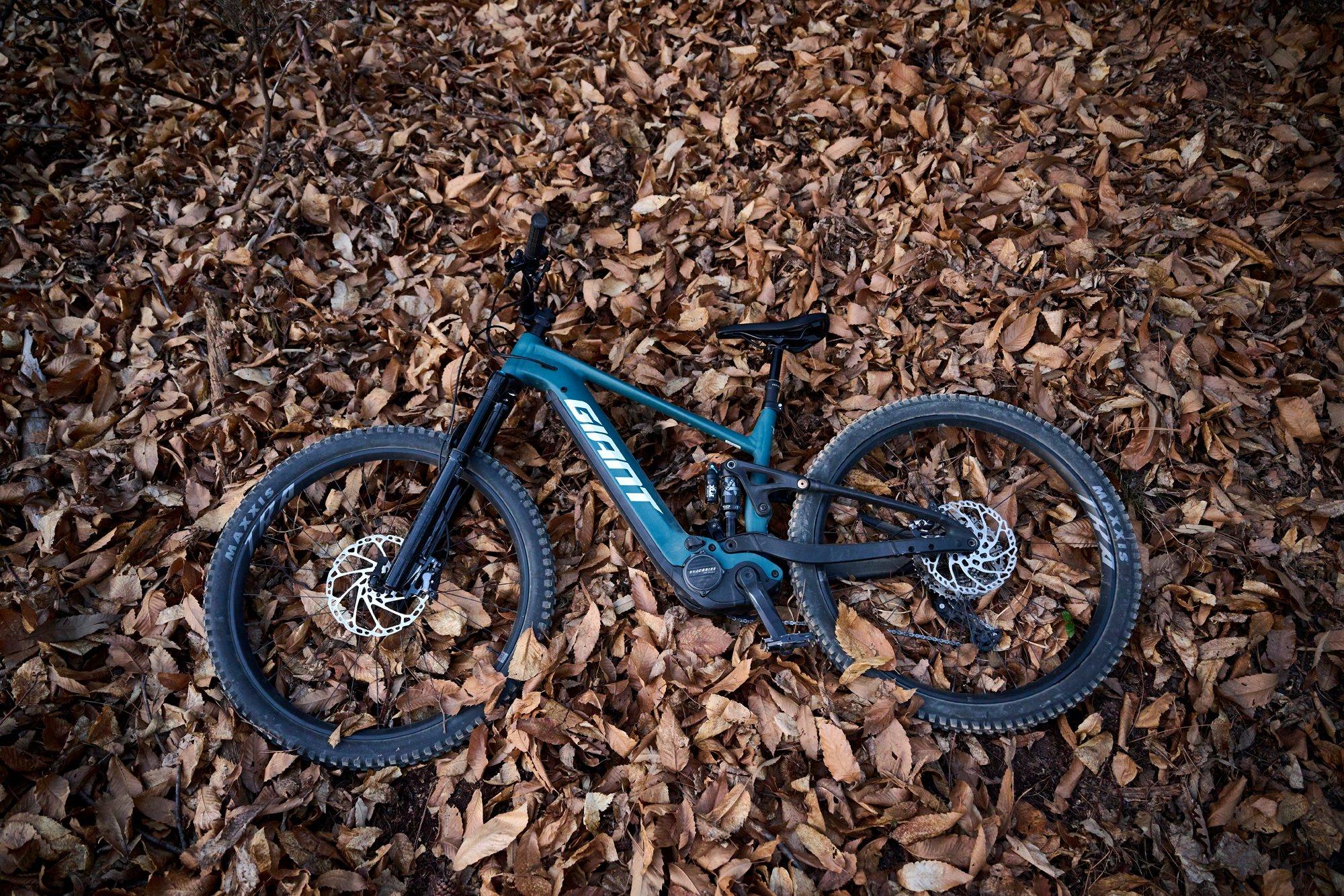 a mountain bike is laying on top of leaves