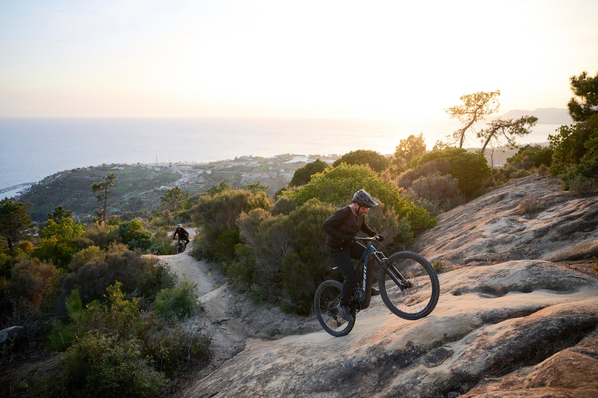 a man riding a mountain bike on a rocky trail