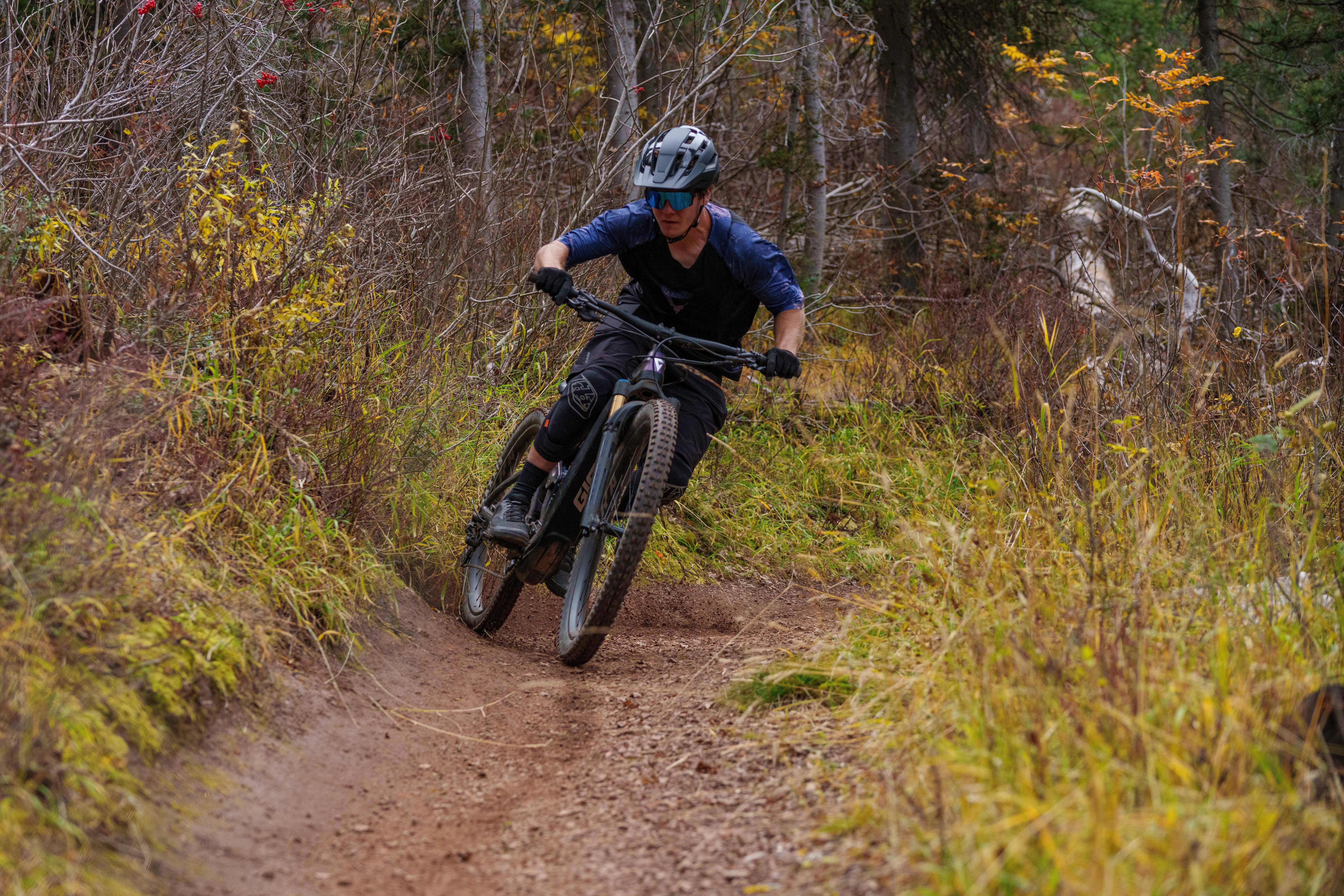 a man riding a mountain bike down a dirt trail