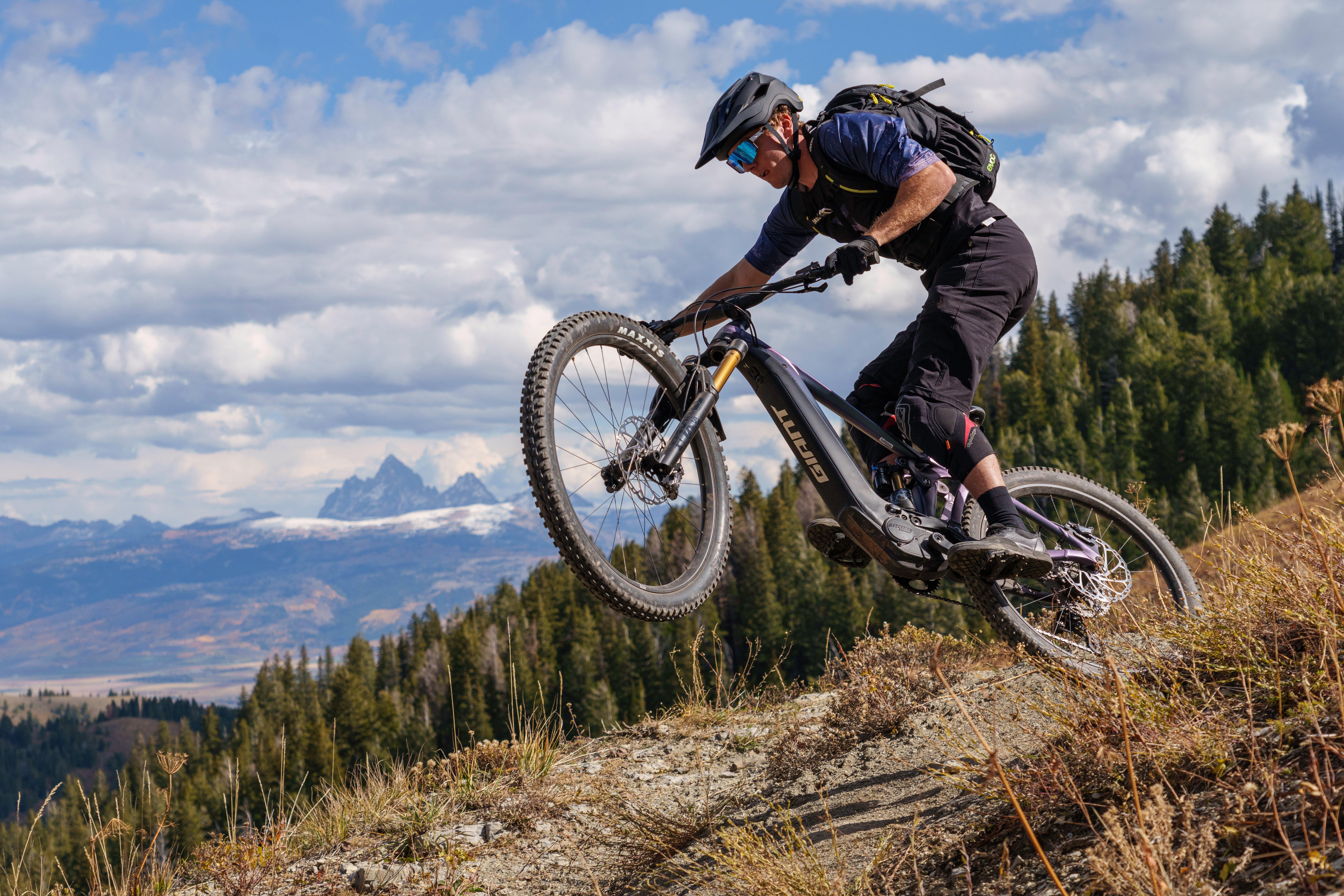 a man riding a mountain bike on a hillside and in the air