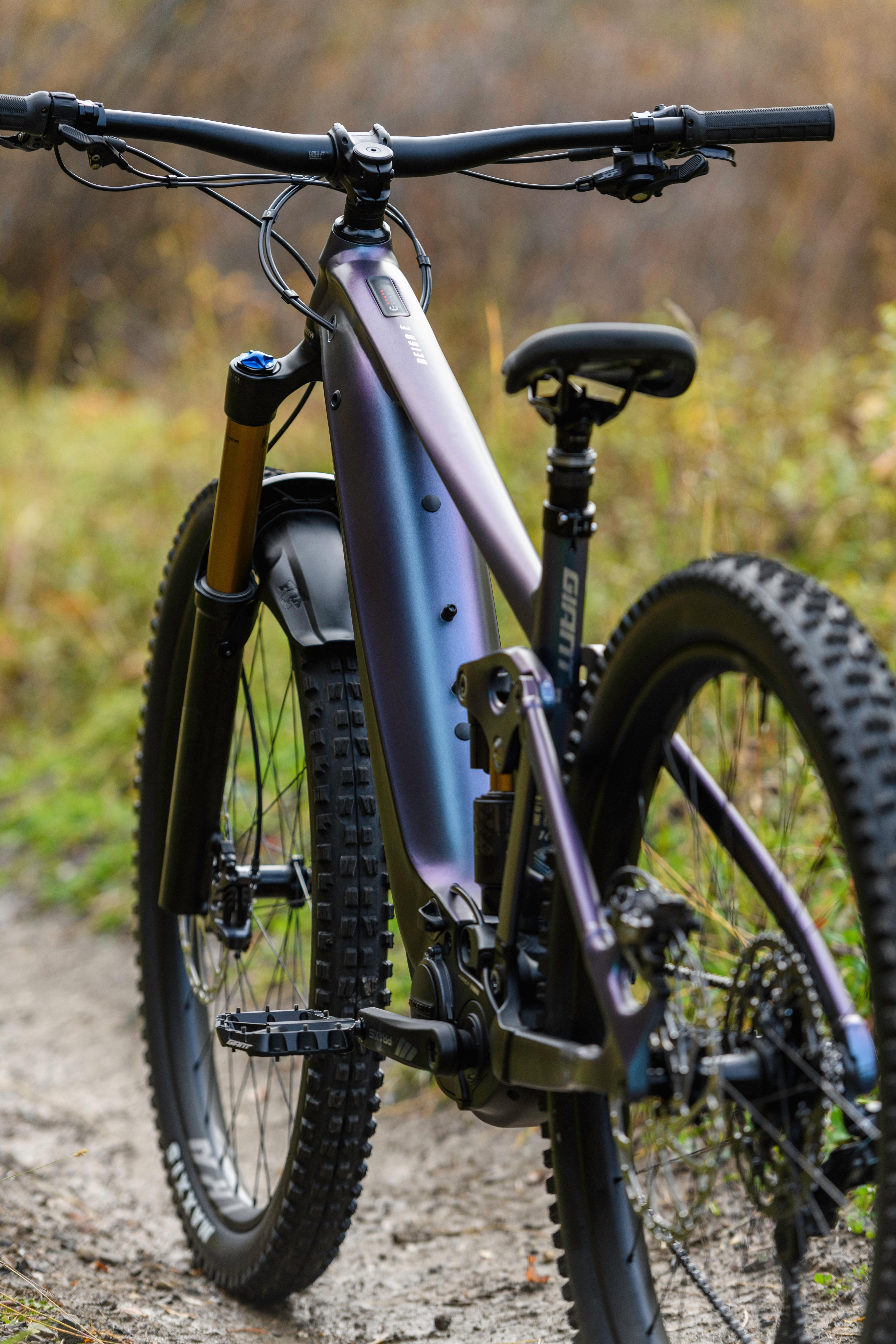 a mountain bike is parked on a dirt road near a forest