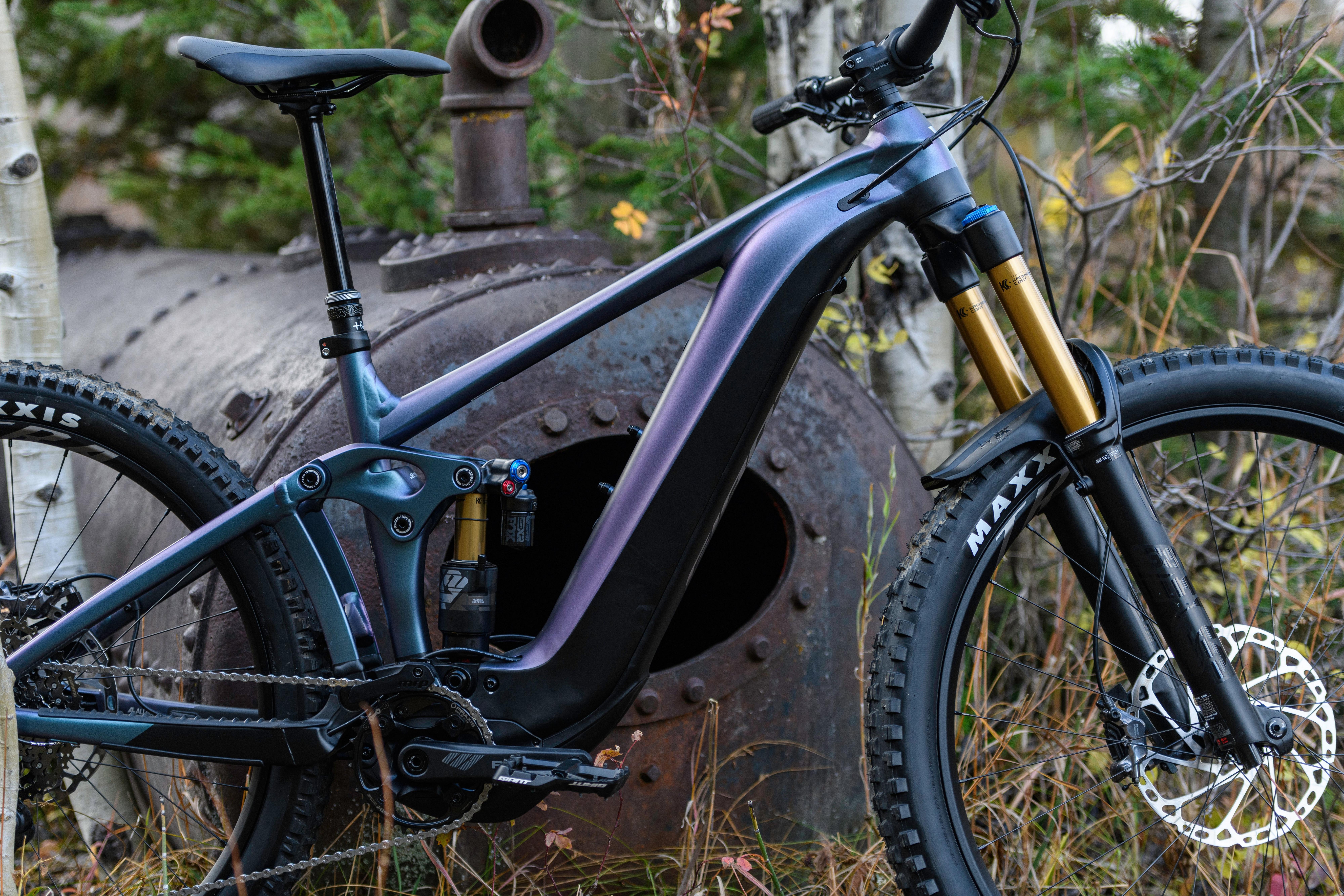 a mountain bike is parked in the woods near a large pipe