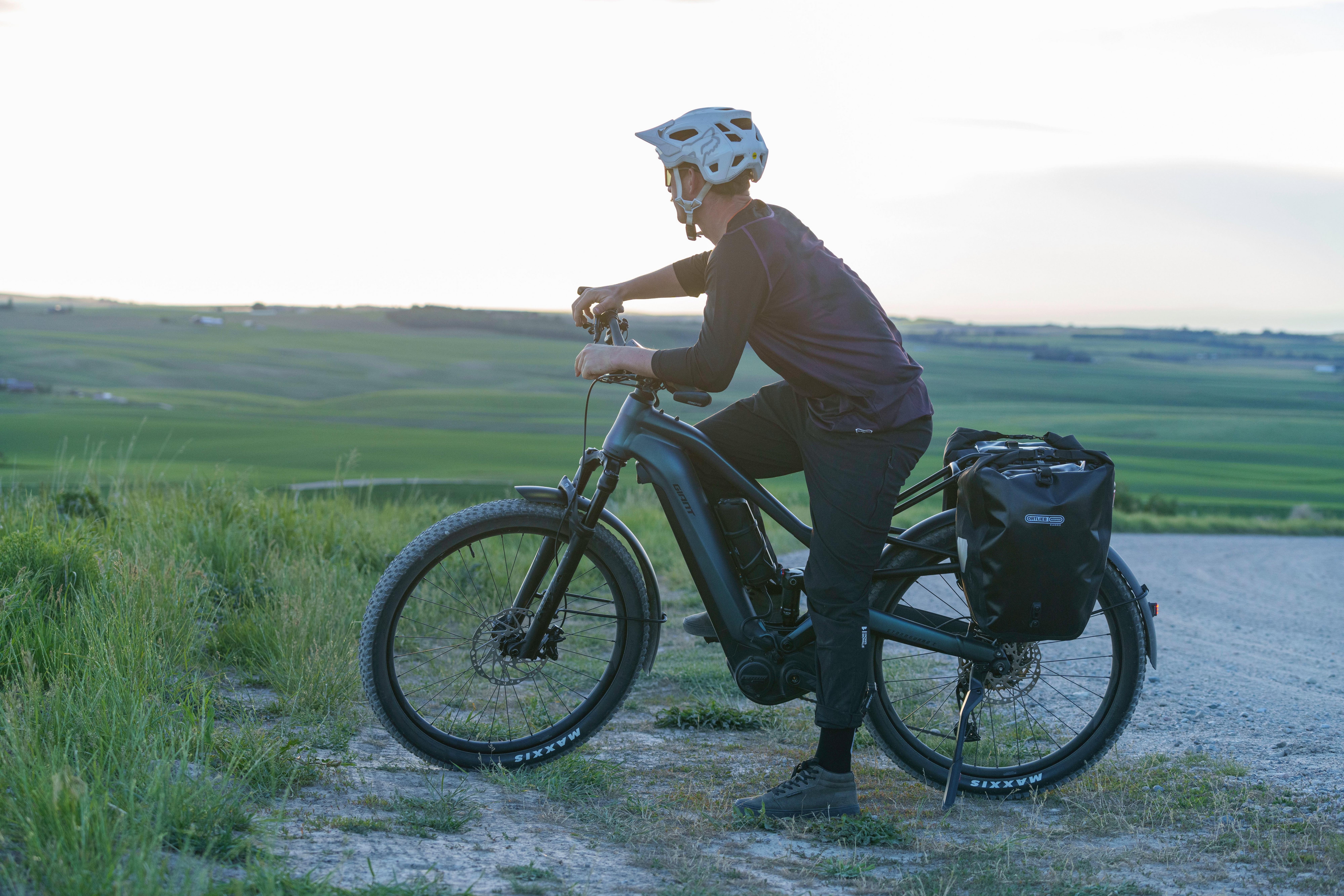 a man in a helmet riding a bike on a dirt road