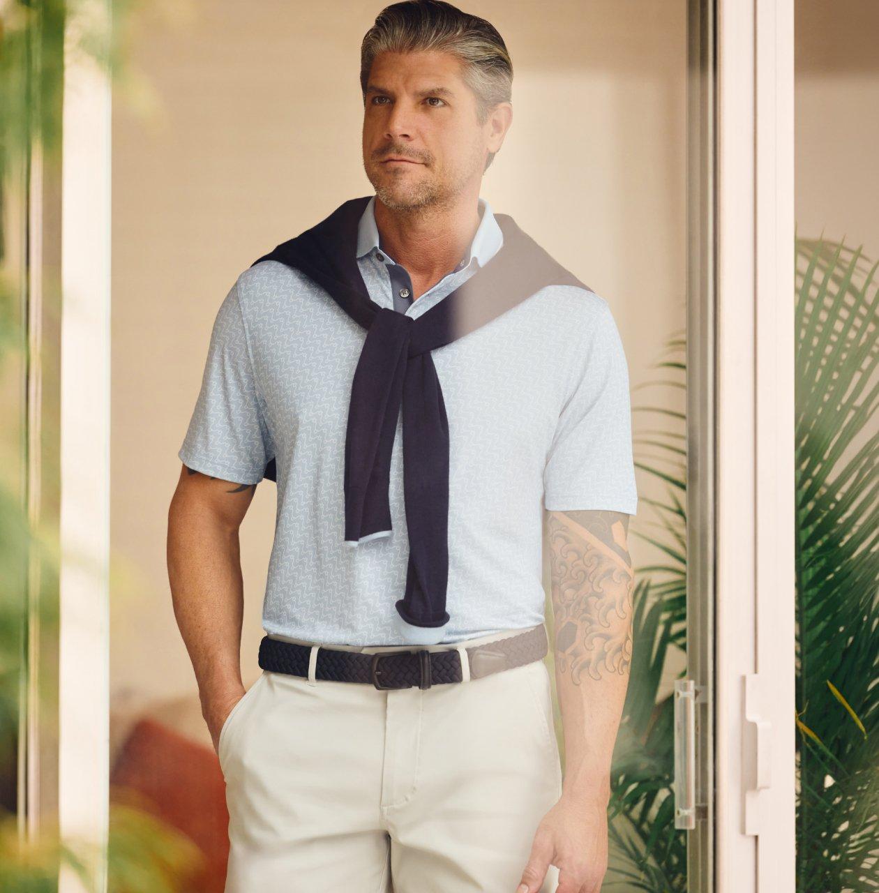 Un homme portant un t-shirt bleu clair avec un short blanc cassé