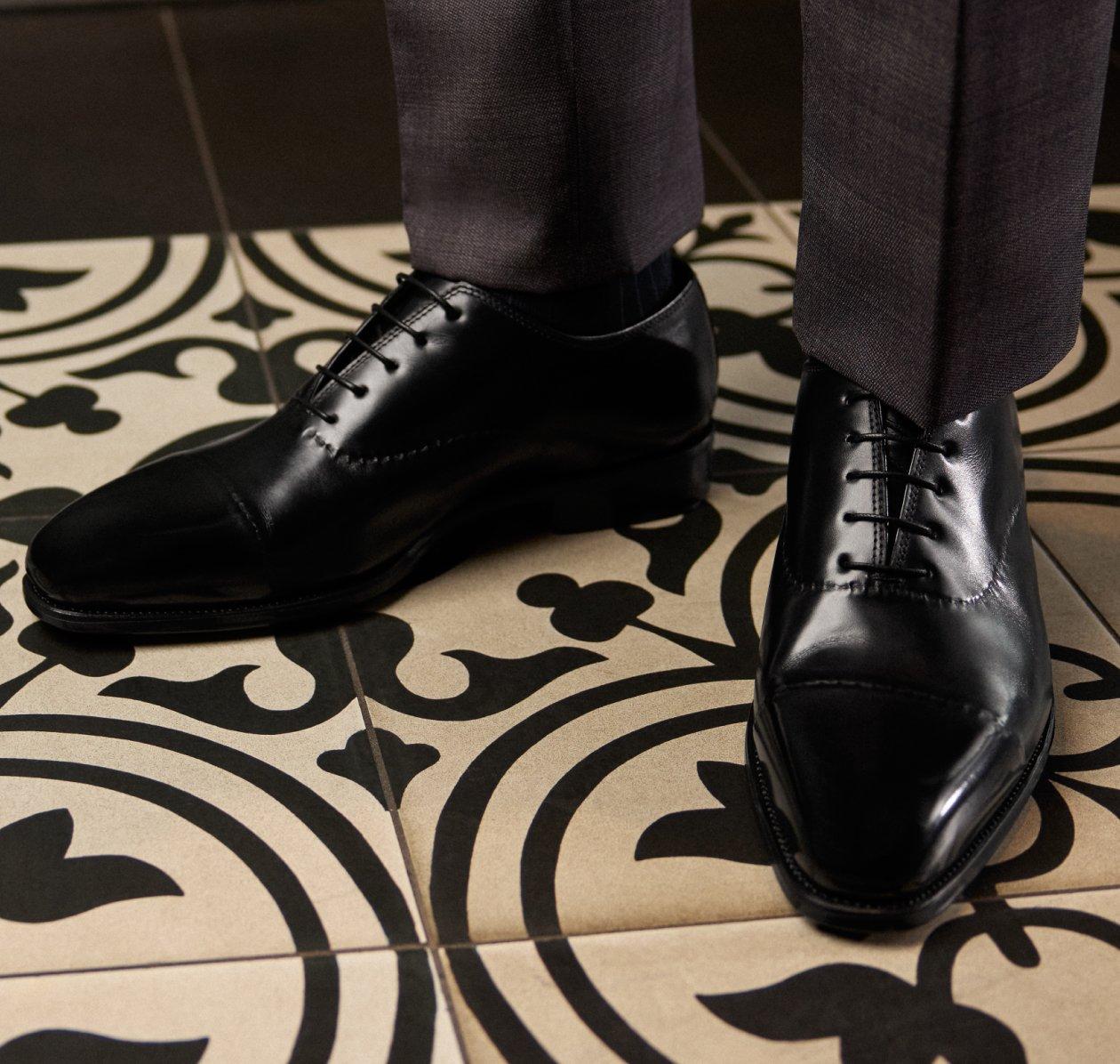 A man wearing a muted brown loafer