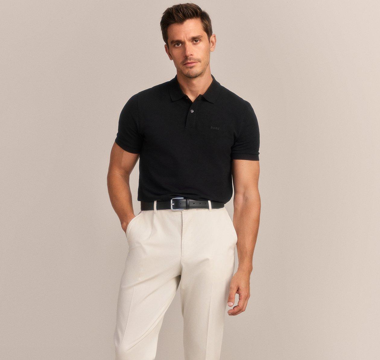 A man wearing a BOSS black polo shirt paired with white pants
