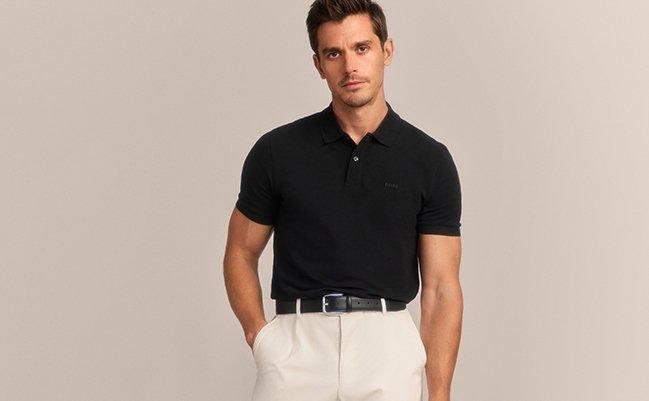 A man wearing a BOSS black polo shirt paired with white pants