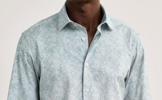 A male model wearing a light blue tailored Bugatchi dress shirt