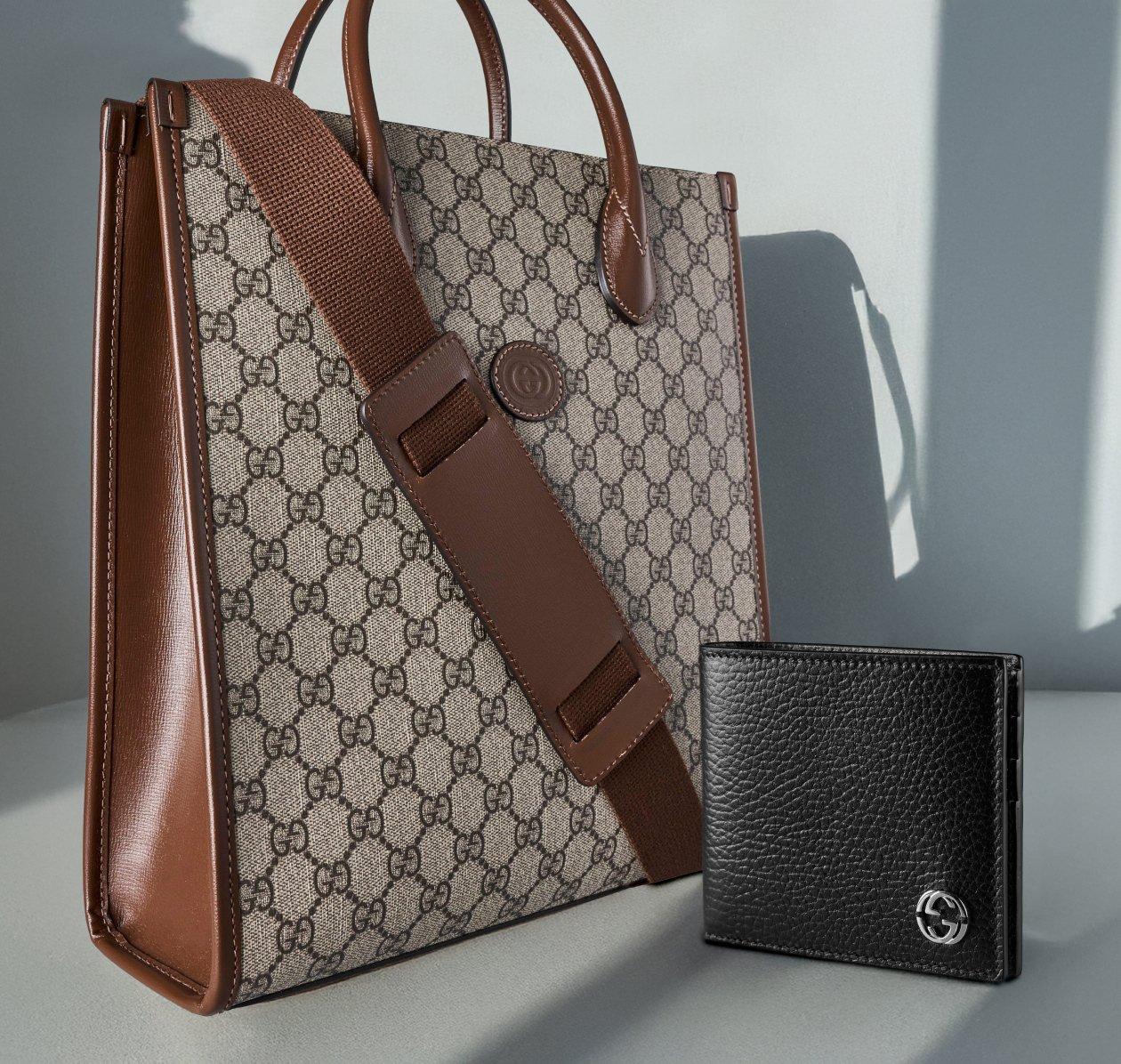 A classic brown leather monogram pattern Gucci bag with a black Gucci emblem wallet