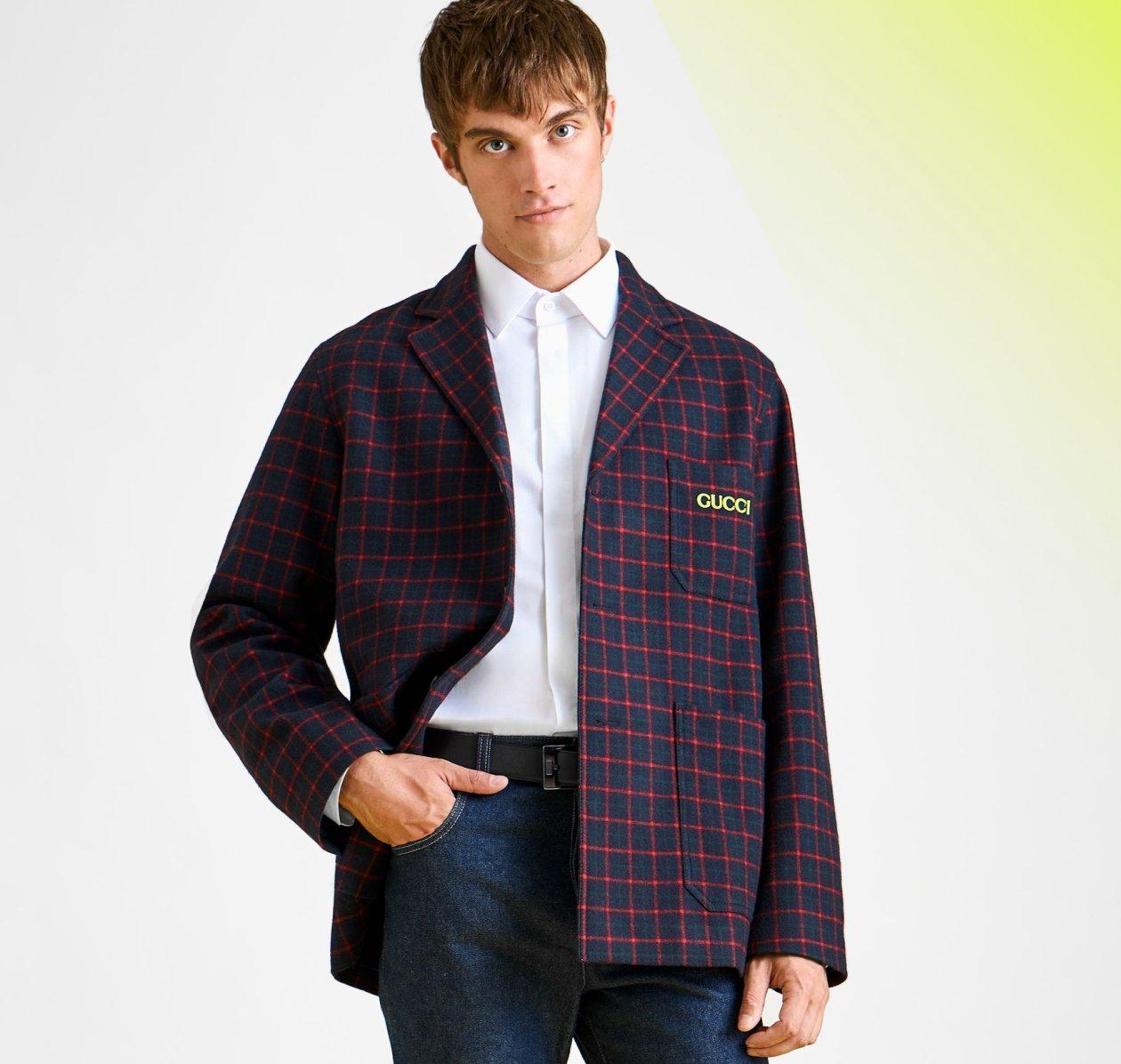 A model wearing a Sport Coat in a light grey wool blend with blue and white checks, paired with a white dress shirt and dark trousers