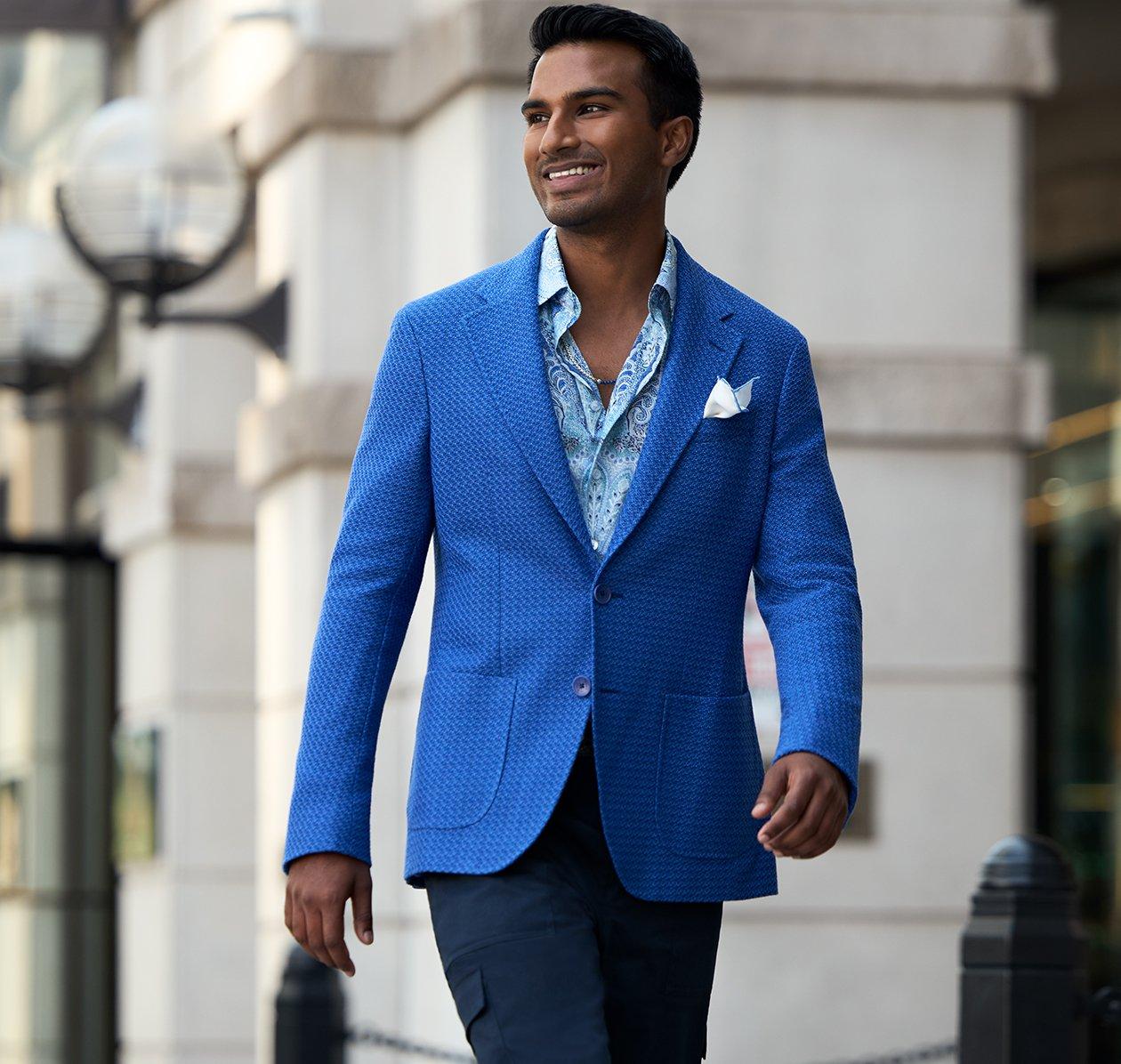 A man wearing a blue sports jacket with denim jeans and a light blue shirt