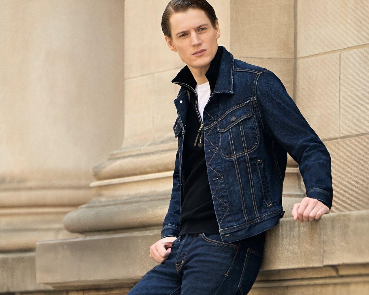 Homme portant une veste en denim superposée à un t-shirt blanc avec un jean bleu foncé