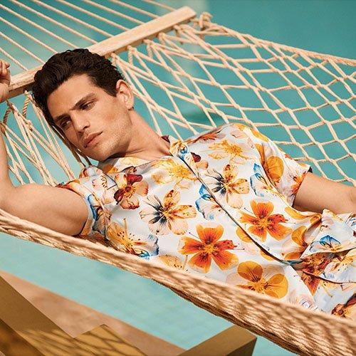 Male model wearing Orlebar Brown sport shirt on hammock to introduce the British brand