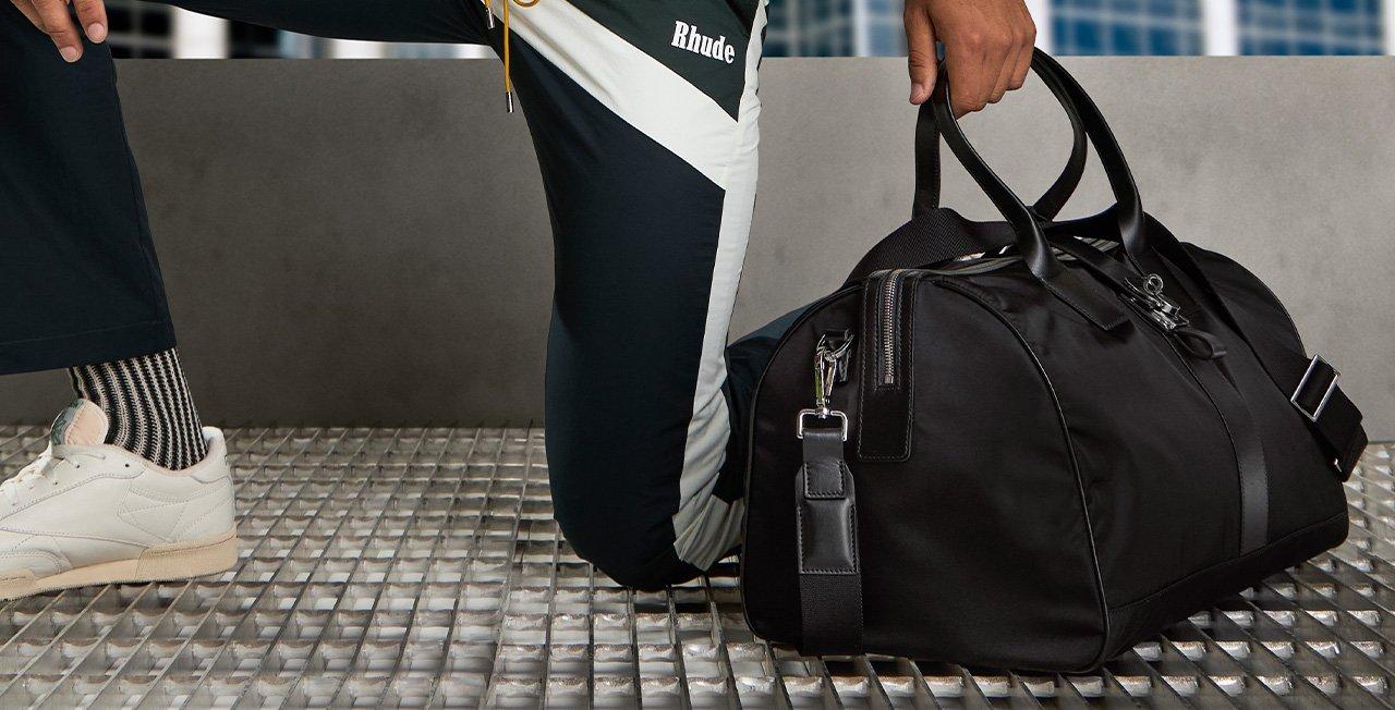 Male in airport holding duffle showcasing travel essentials