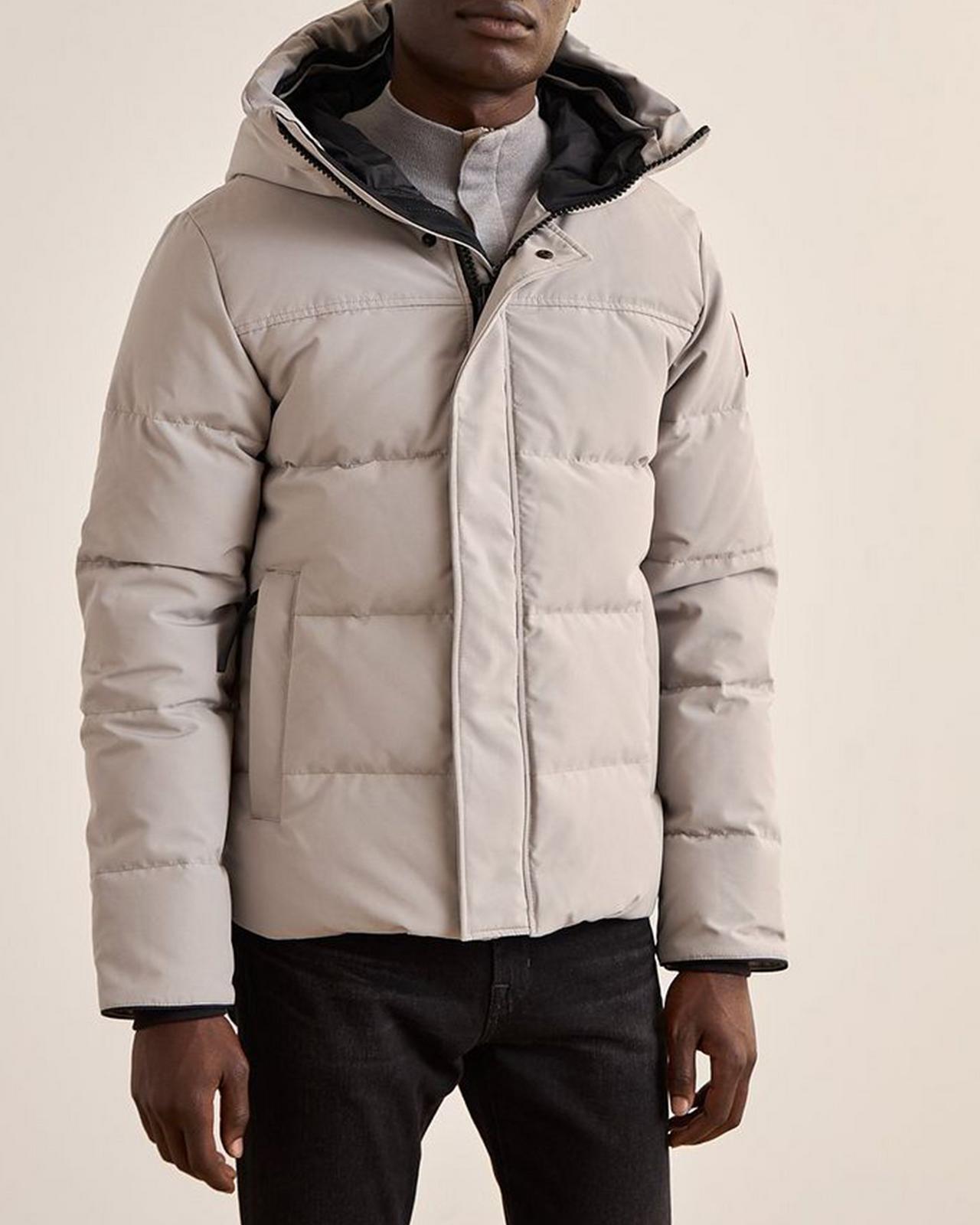 Modèle masculin portant une parka illustrant les hivers doudounes et parkas non négociables