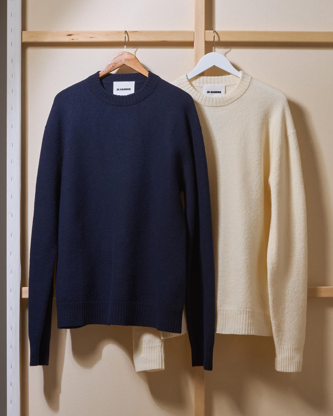 Two crewneck sweaters on hangers illustrating sweaters & knits