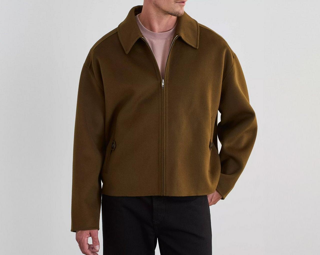 A man wearing Acne Studios brown puffer jacket with black pants 