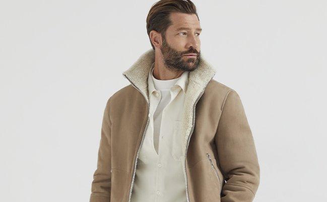 A man wearing a beige Brunello Cucinelli jacket over a white shirt