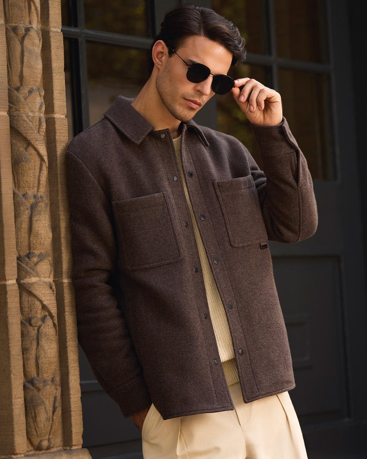 A man wearing a light purple overshirt with off-white pants 