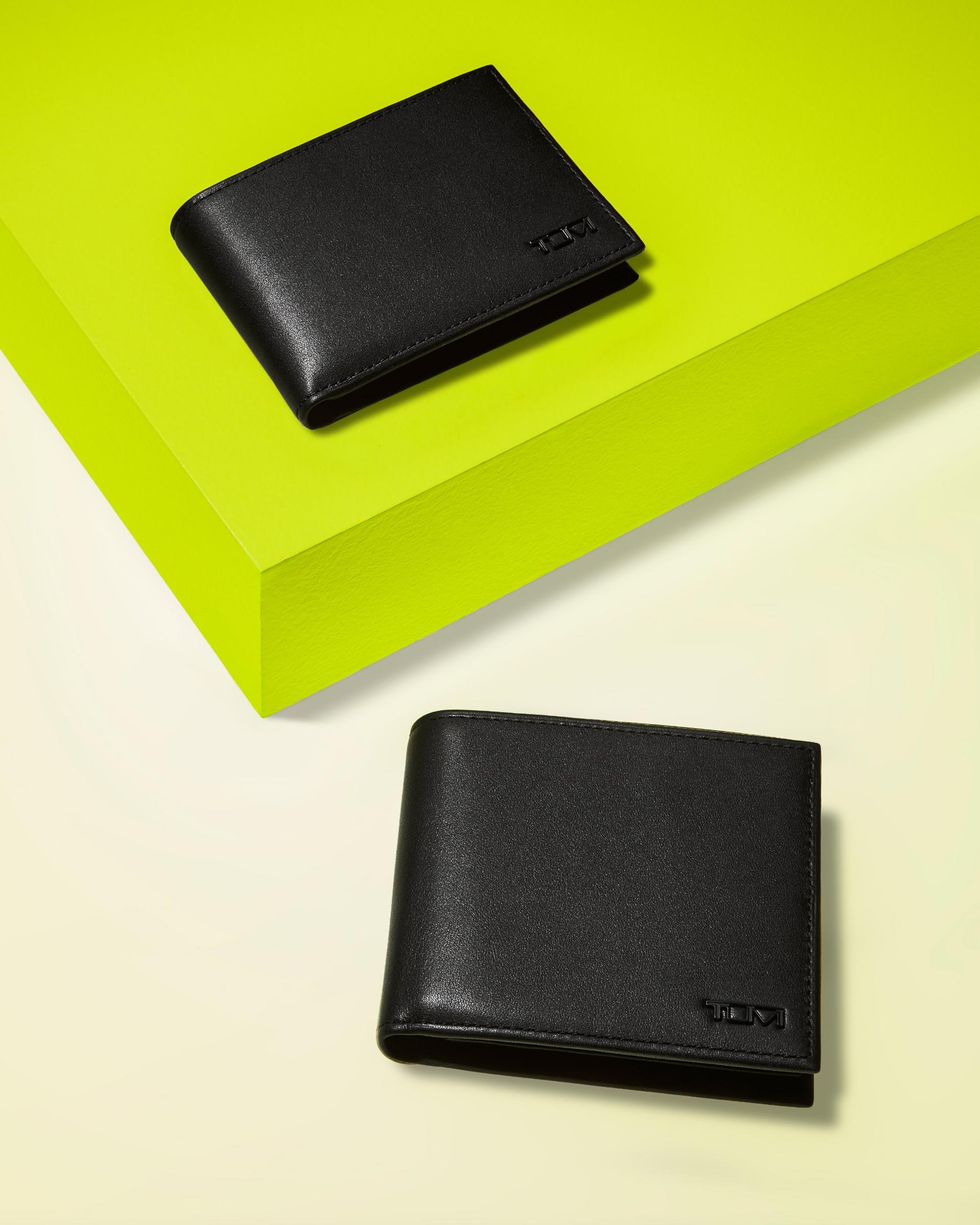 Two black leather wallets styled around a neon green display