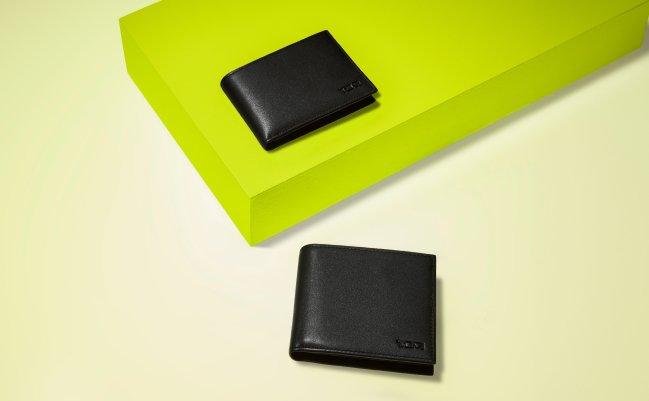 Two black leather wallets styled around a neon green display