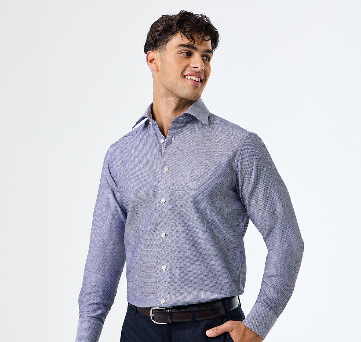A male model wearing a blue dress shirt with white buttons