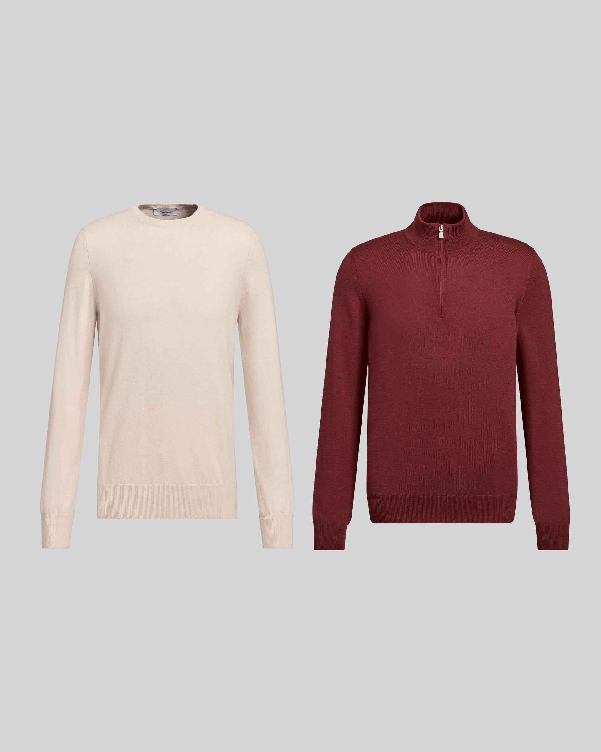 A burgundy wool 1/4 zip sweater and a cream wool sweater displayed on a grey background