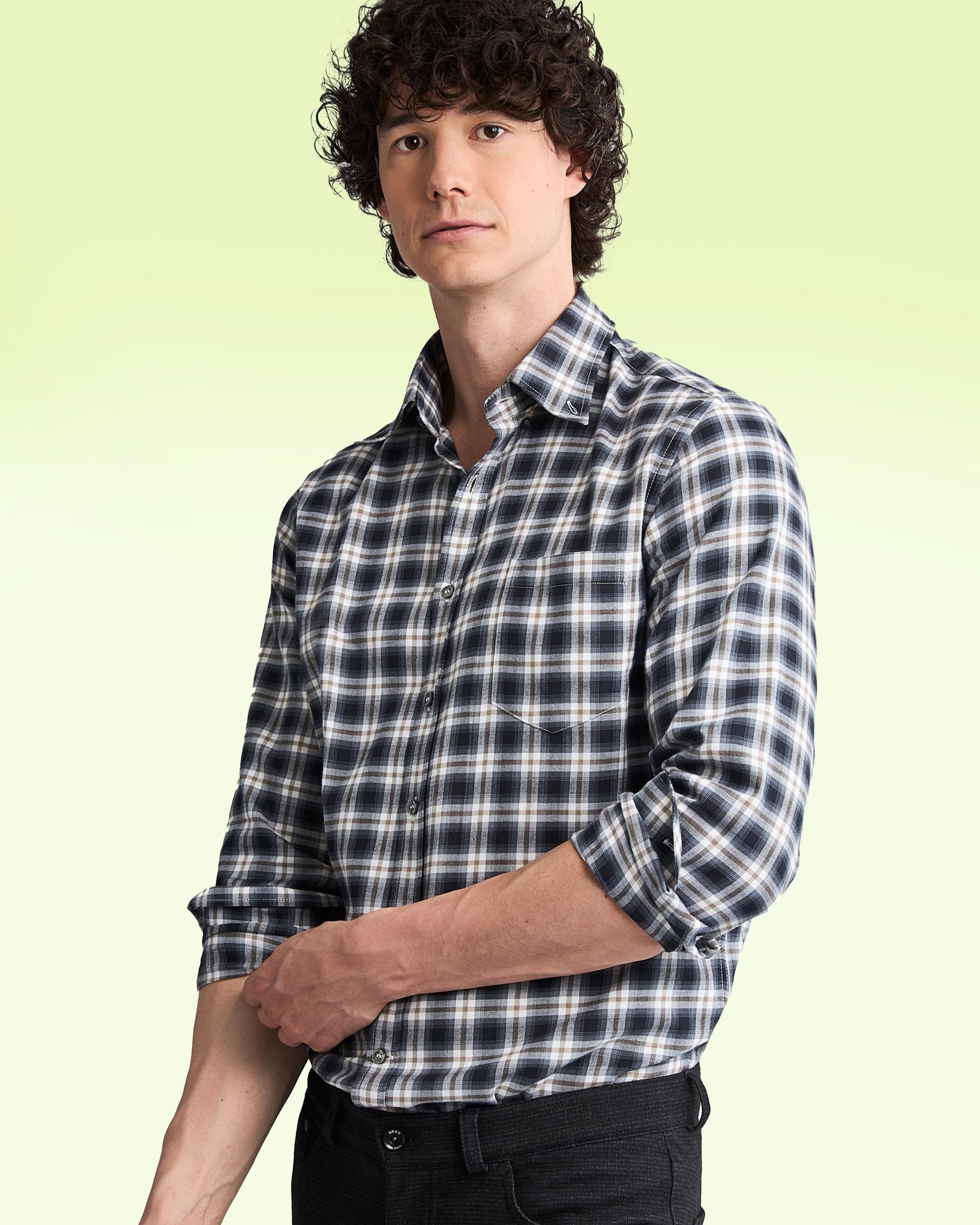 A model wearing a plaid black and white casual shirt with brown accents
