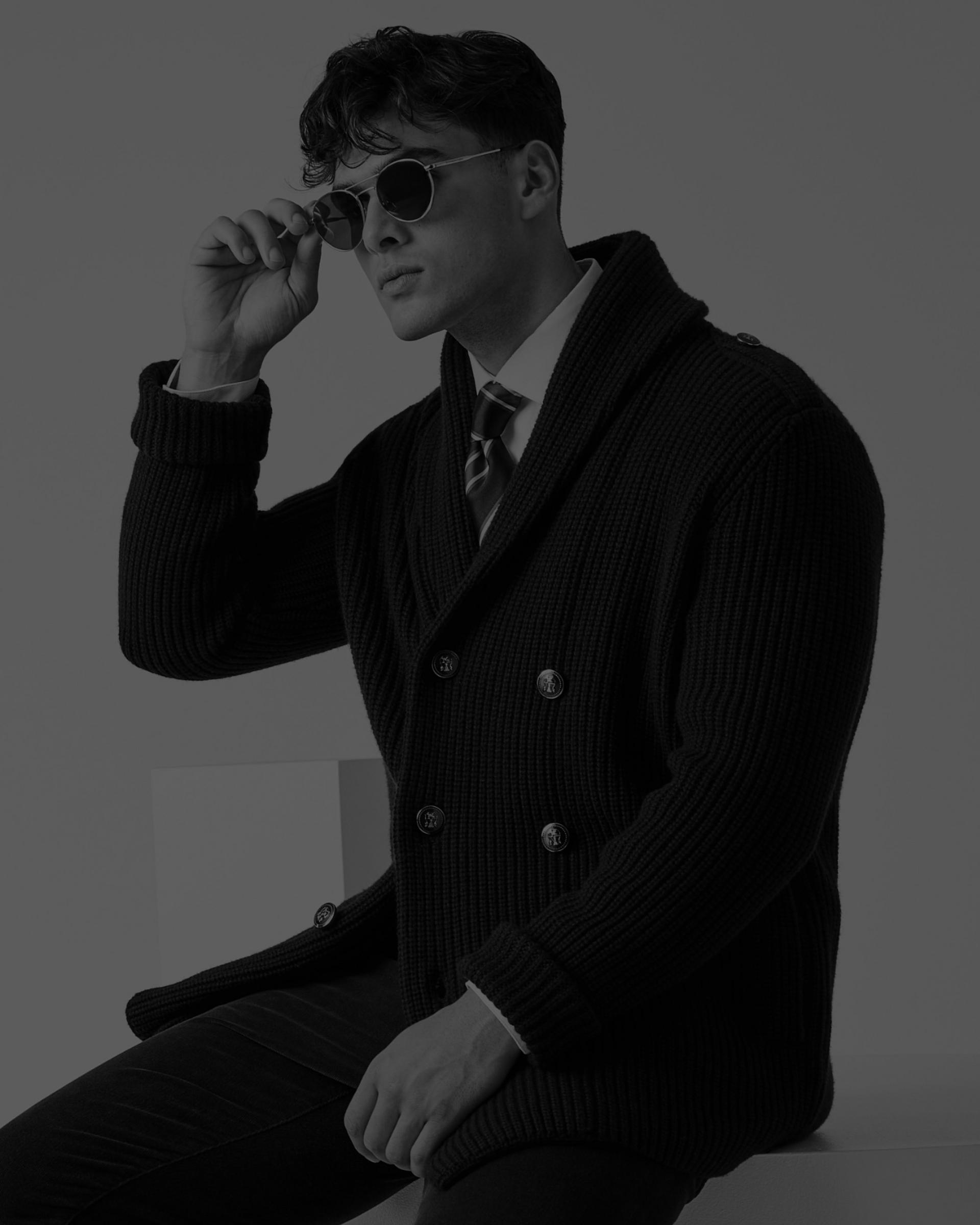 A male model wearing a blue knit sweater