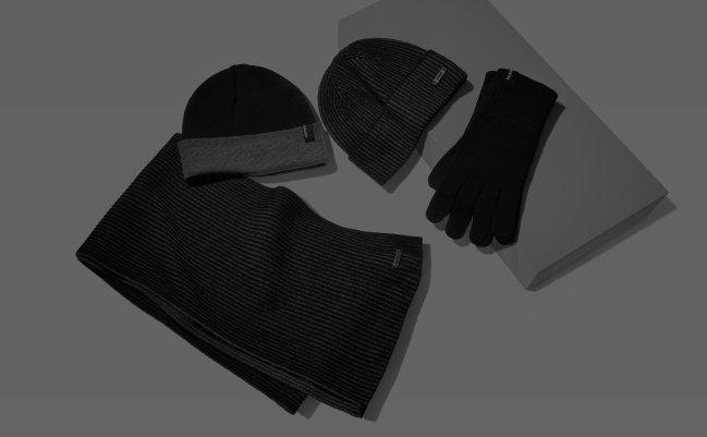 Un ensemble d’accessoires d’hiver gris et noirs présenté sur un plateau