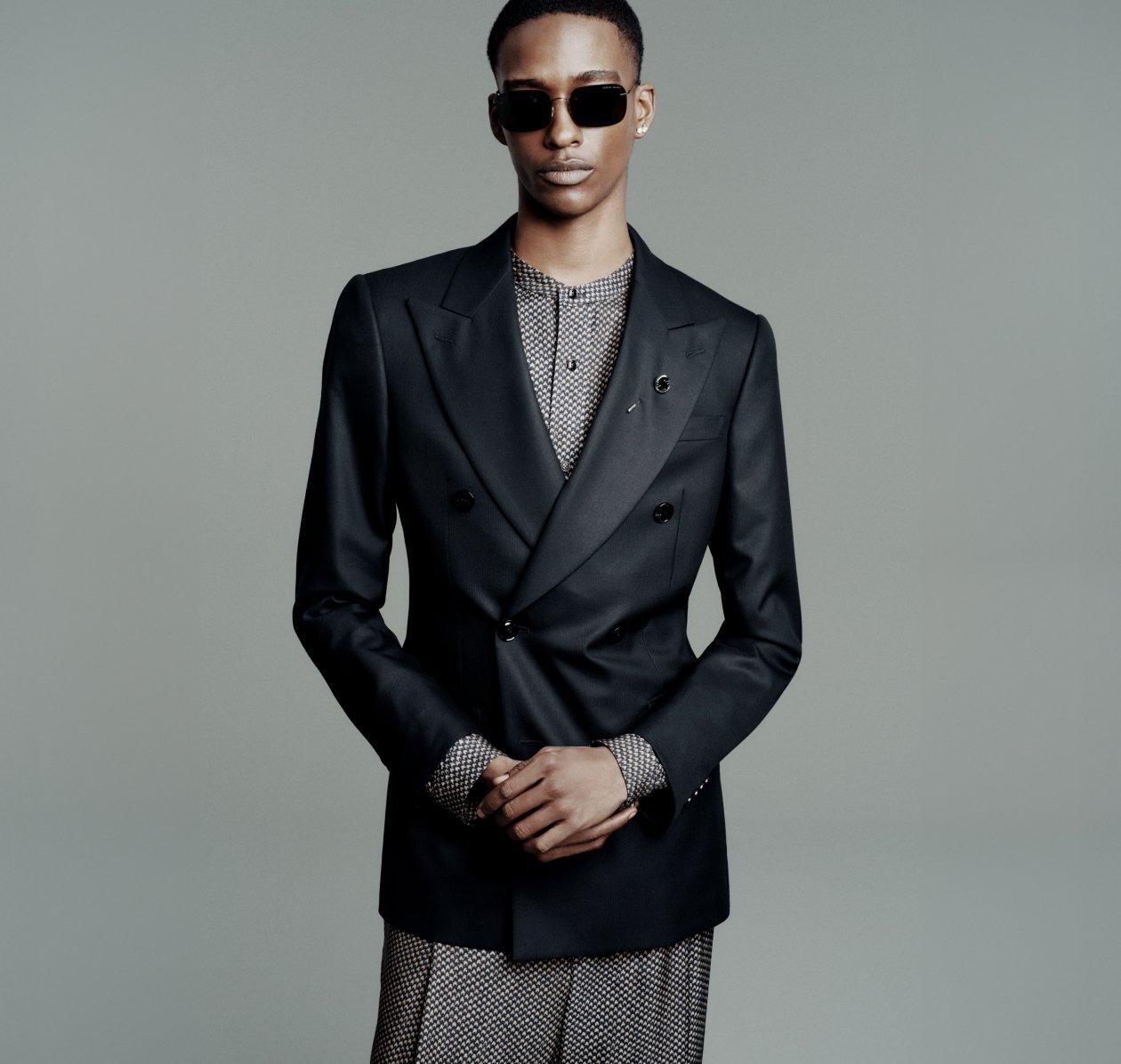 Homme portant un veston croisé noir Giorgio Armani avec une chemise grise et des lunettes de soleil