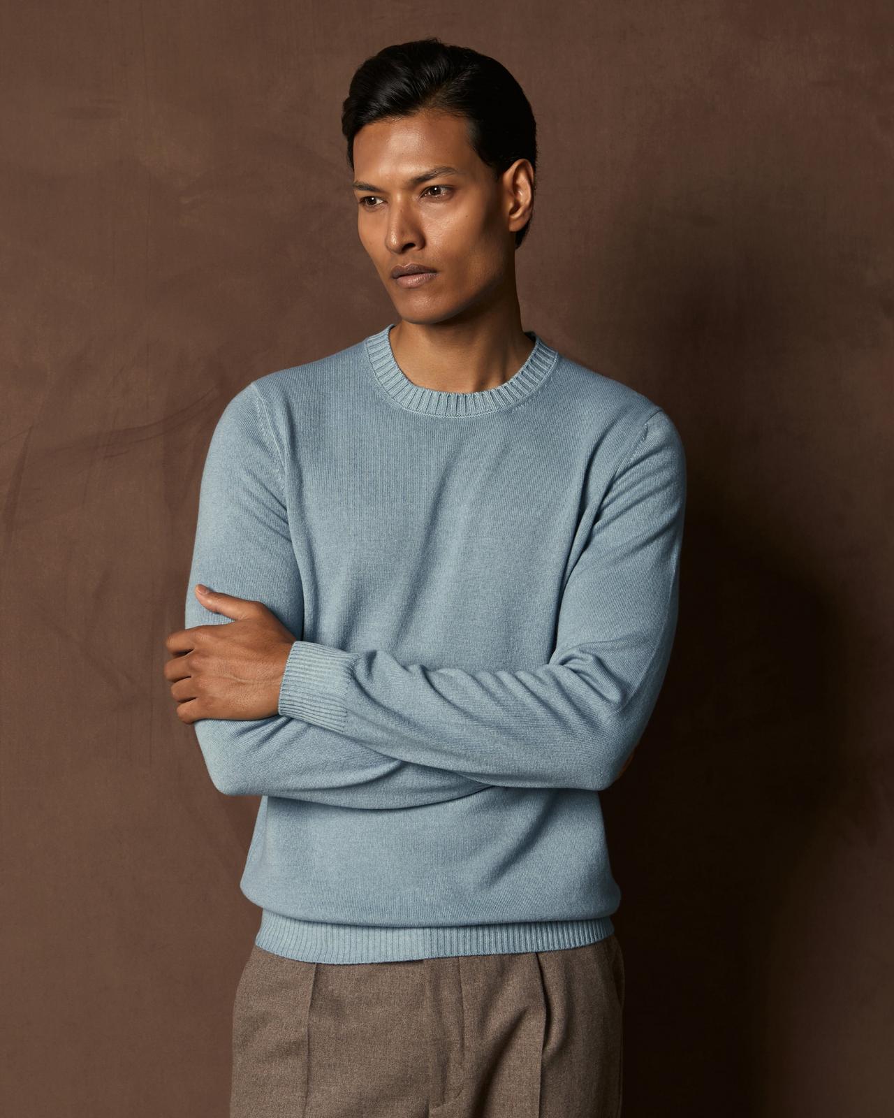 A man wearing a light blue cardigan