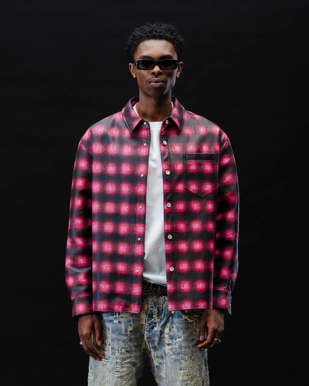 A male model wearing a red and black plaid Purple Brand casual shirt paired with a white shirt and sunglasses