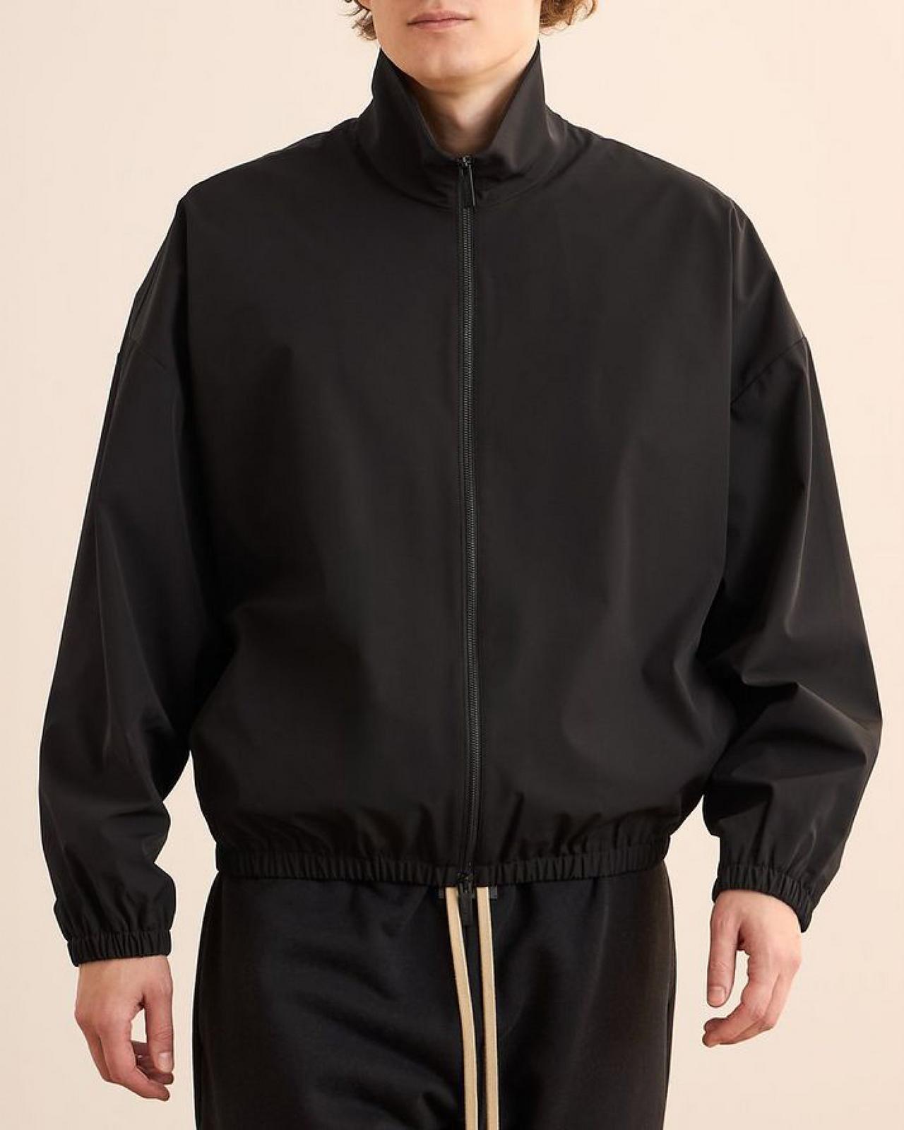 Un homme portant une veste noire avec un pantalon de jogging noir