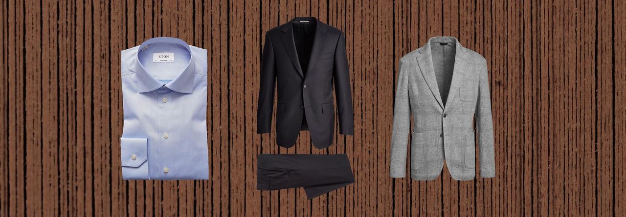 Manteau gris pâle, complet gris foncé et chemise habillée blanche sur fond brun.