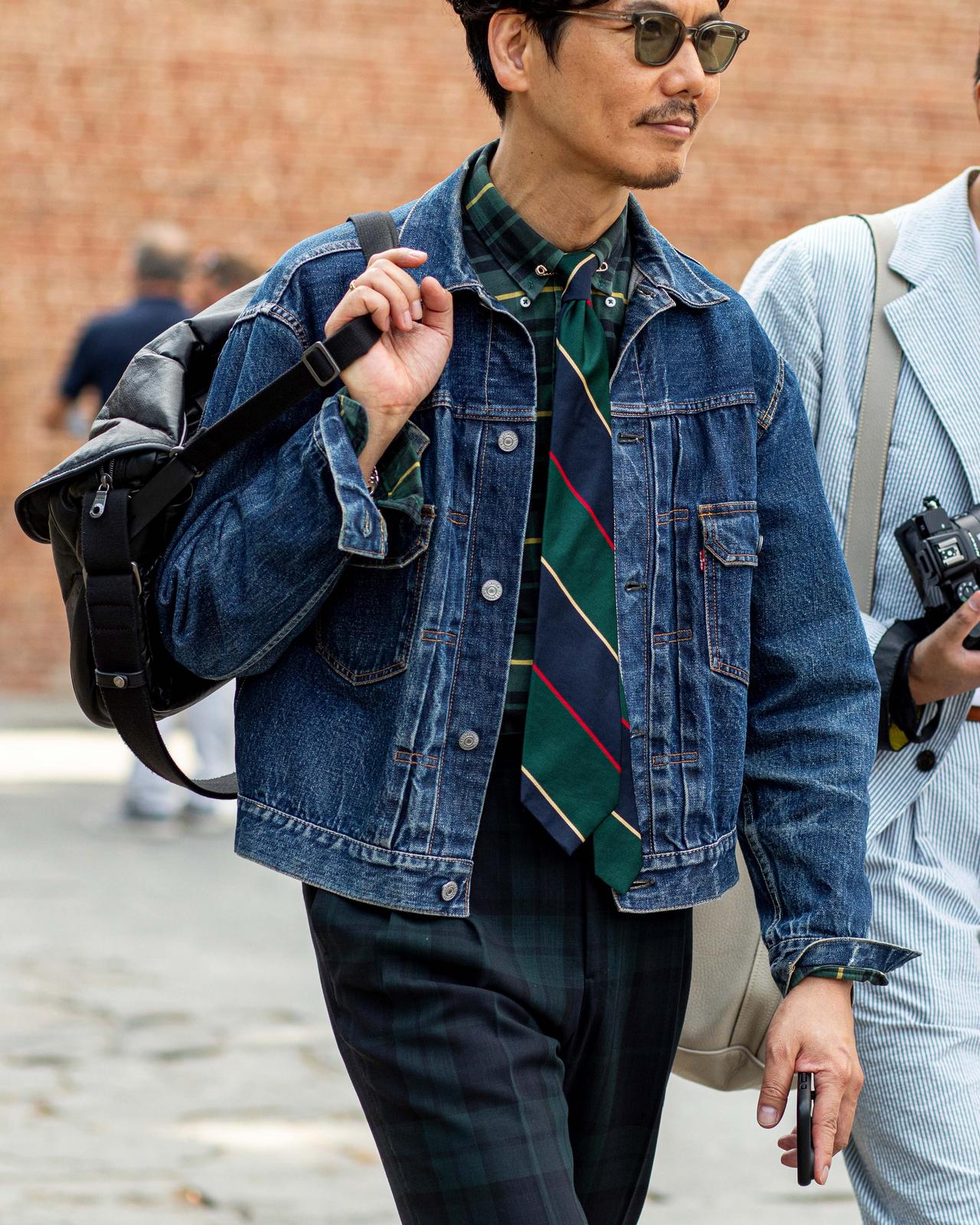 Homme portant une veste en denim par-dessus une chemise et une cravate