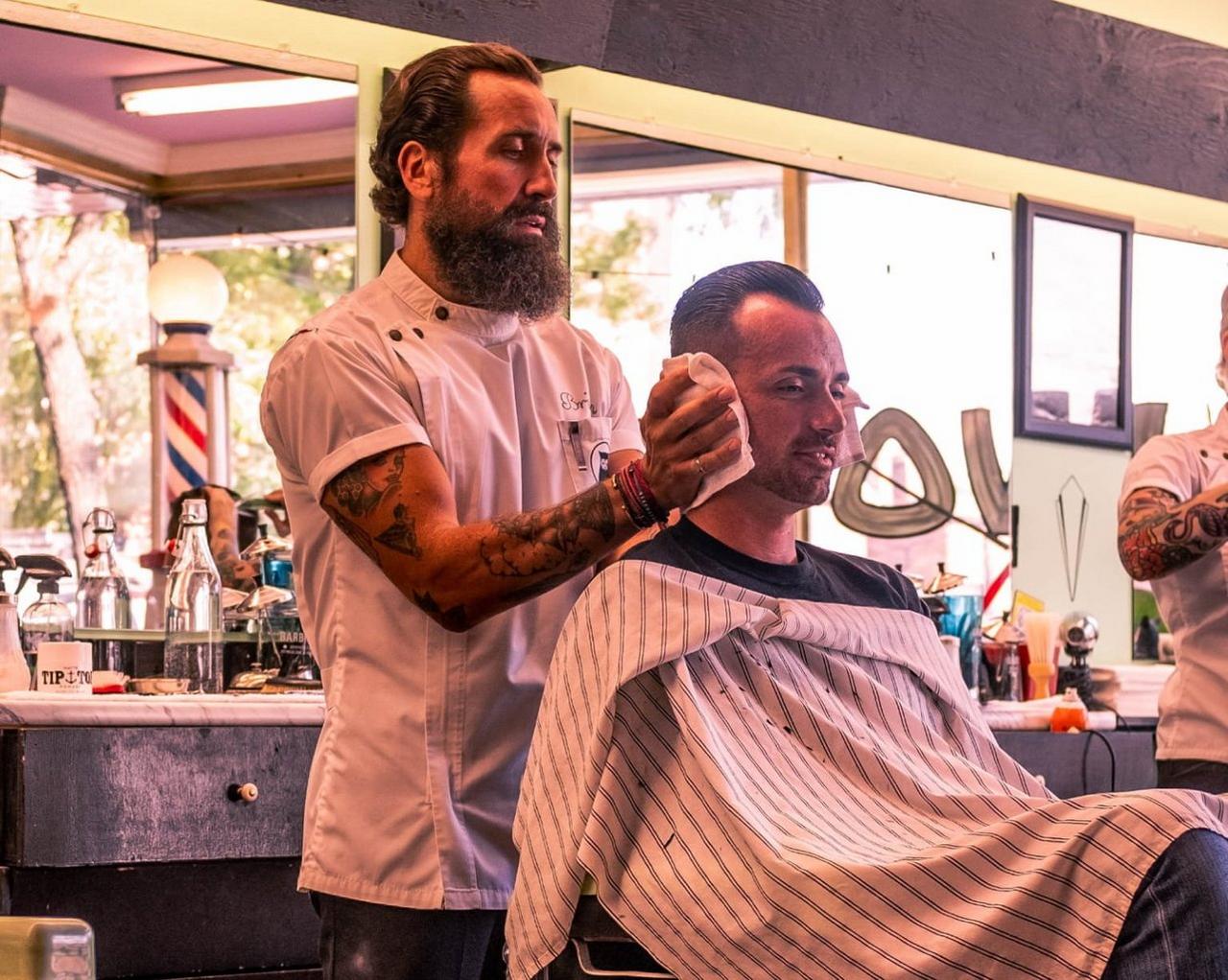 Brian Hurson, un coiffeur, avec un client dans un salon